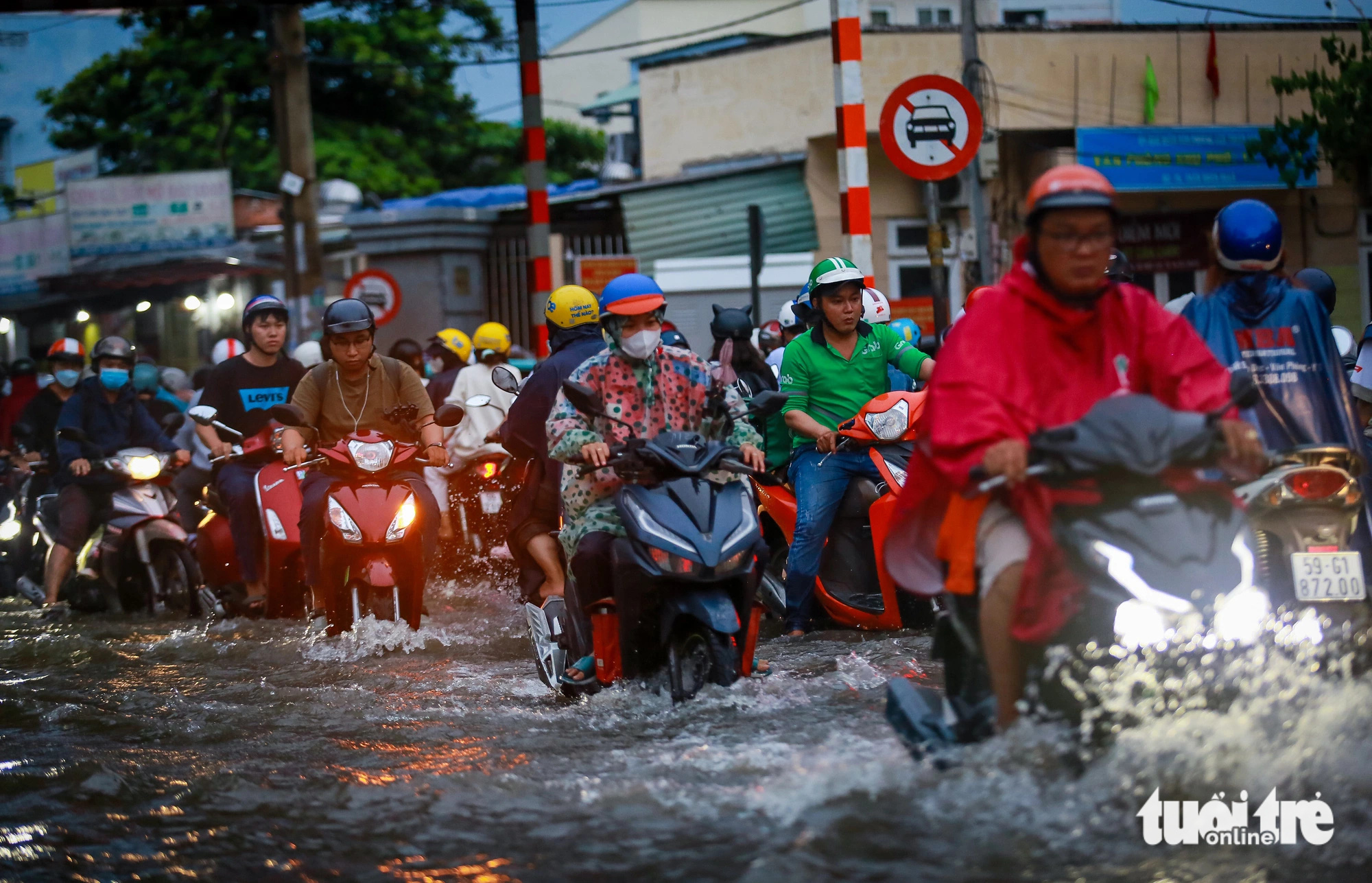 Vehicles wade through the flooded Tran Xuan Soan Street in District 7, Ho Chi Minh City during high tides, September 20, 2024. Photo: Le Phan / Tuoi Tre