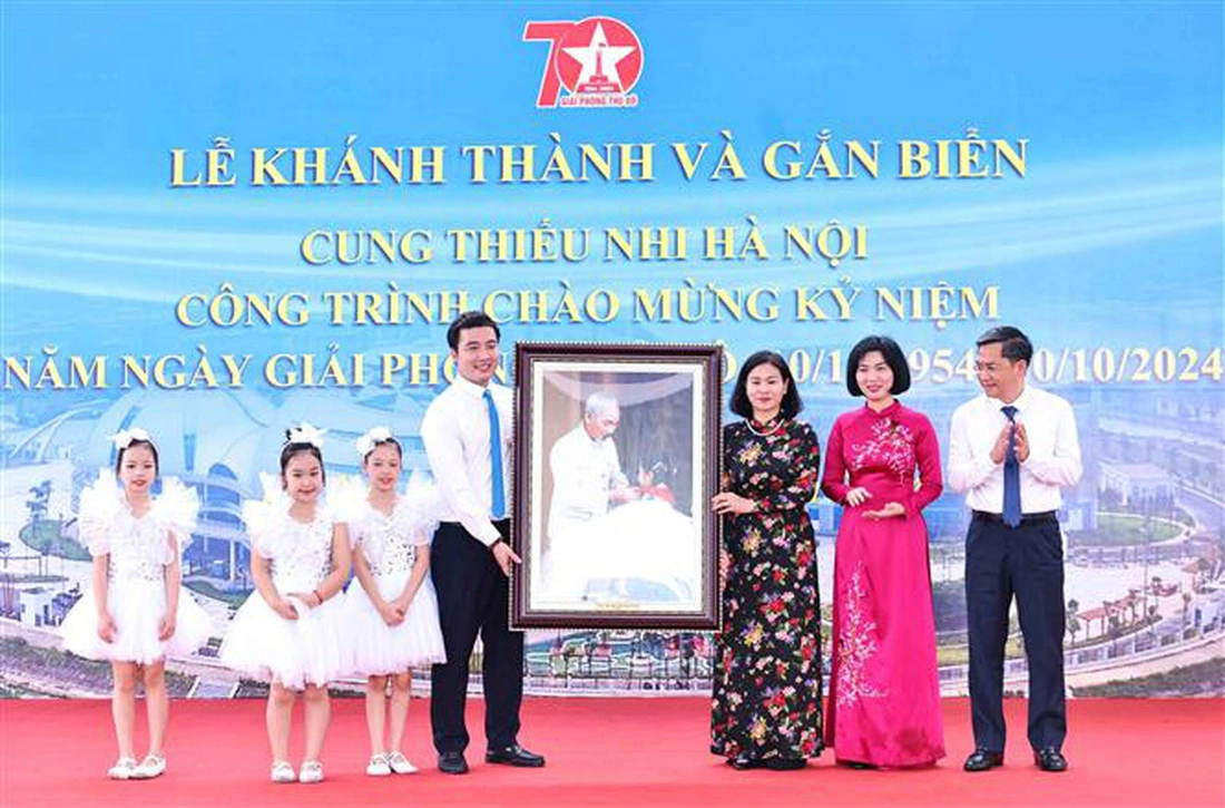 Permanent Deputy Secretary of the Hanoi Party Committee Nguyen Thi Tuyen (R, 3rd) presents a painting depicting late President Ho Chi Minh and a child to the Hanoi Children's Palace. Photo: Vietnam News Agency