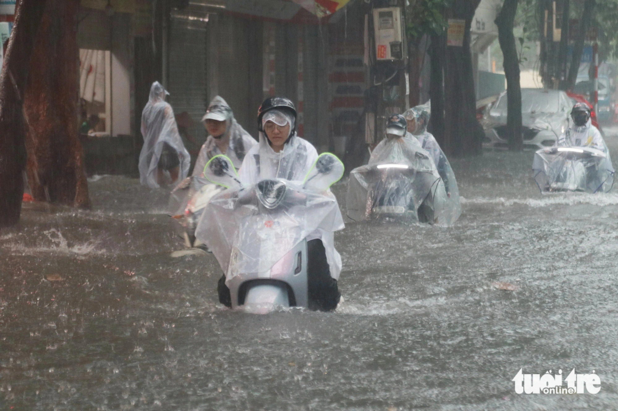 Students struggle to wade through a flooded street to return home after their schools announced temporary closures due to bad weather in Vinh City, Nghe An Province, north-central Vietnam, September 23, 2024. Photo: Doan Hoa / Tuoi Tre