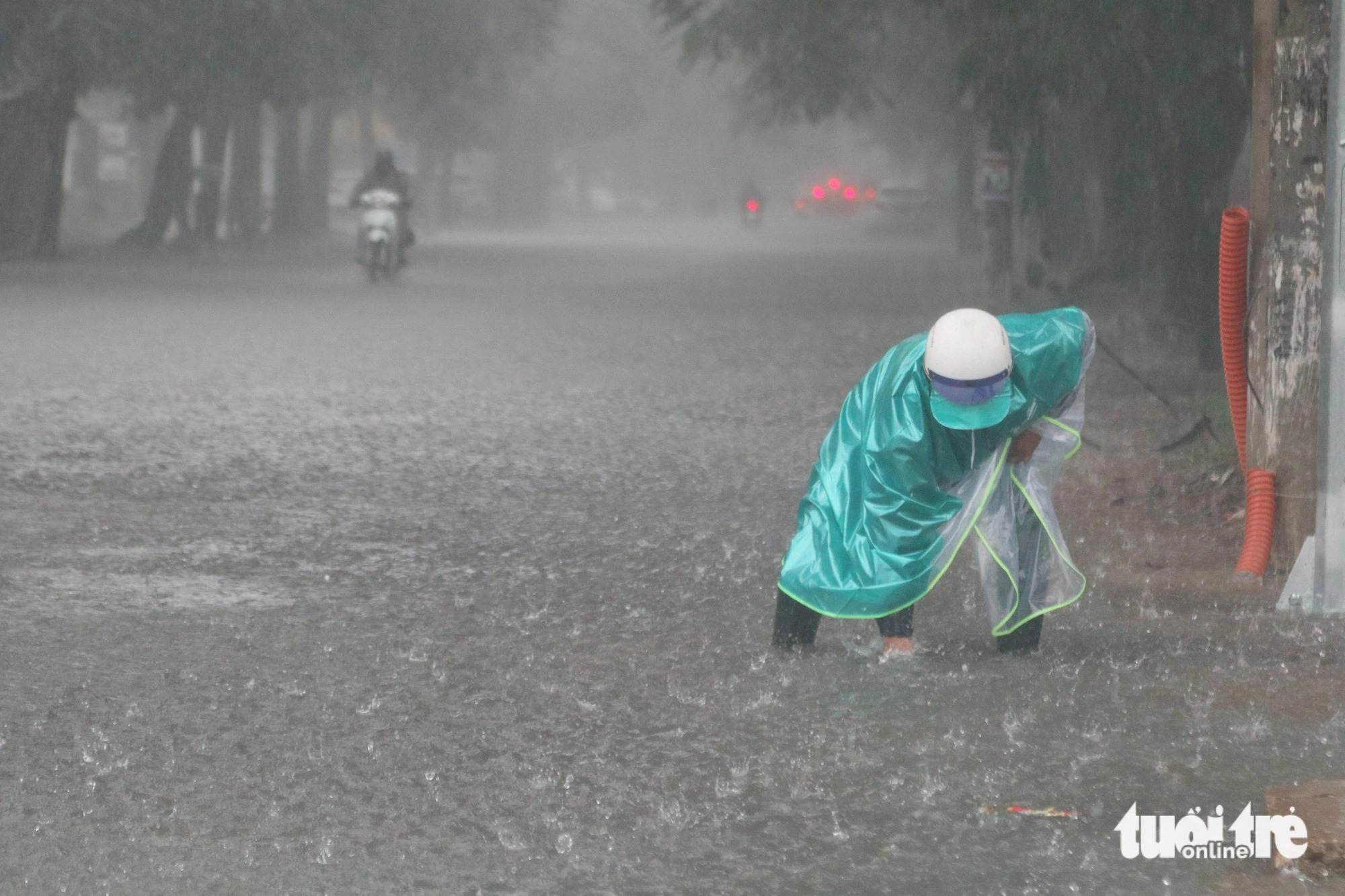 An urban sanitation worker removes trash to unblock a manhole in Vinh City, Nghe An Province, north-central Vietnam, September 23, 2024. Photo: Doan Hoa / Tuoi Tre