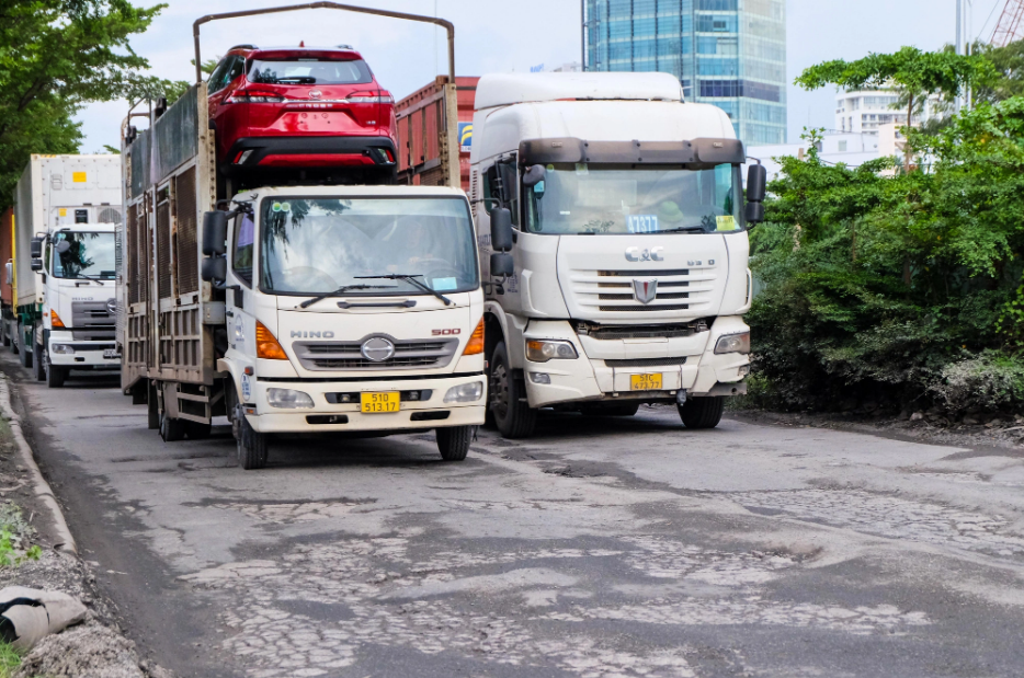 The sheer number of trucks and cars on Nguyen Van Linh Street, District 7 contributes to the deterioration of its surface. Photo: Phuong Nhi / Tuoi Tre