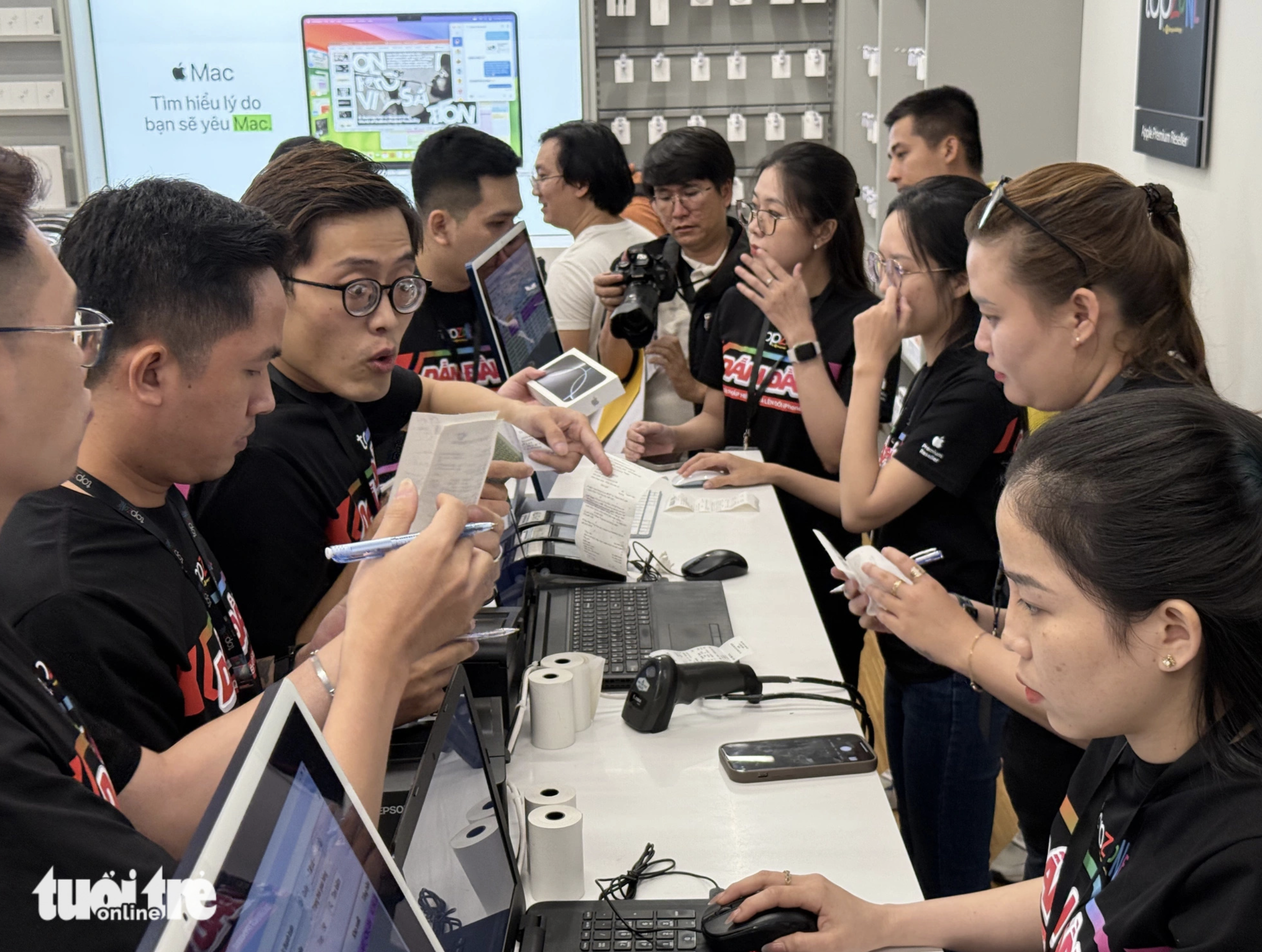 Topzone employees hand over iPhone 16s to customers. Photo: Duc Thien / Tuoi Tre