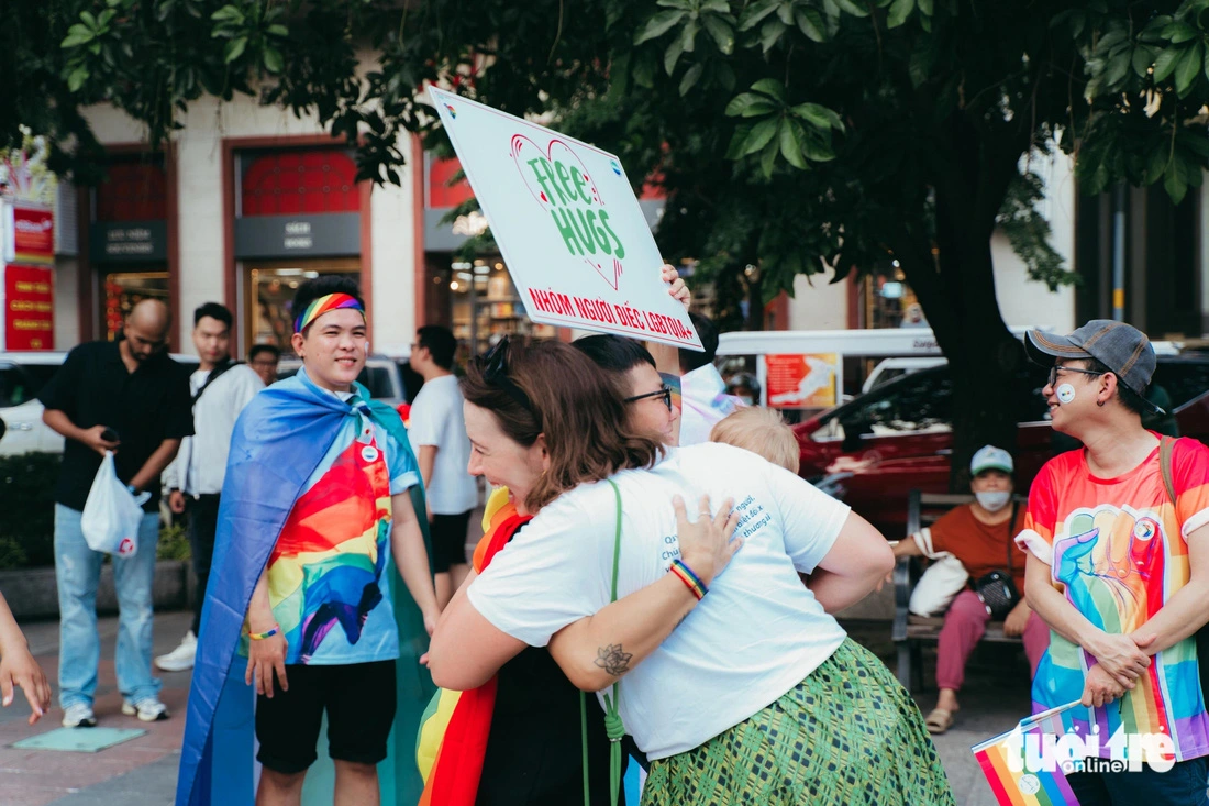 A foreign woman, in a white T-shirt, cheerfully hugs a participant in the parade of the LGBTI+ community on Nguyen Hue Pedestrian Street in District 1, Ho Chi Minh City, September 28, 2024. Photo: Thanh Hiep / Tuoi Tre