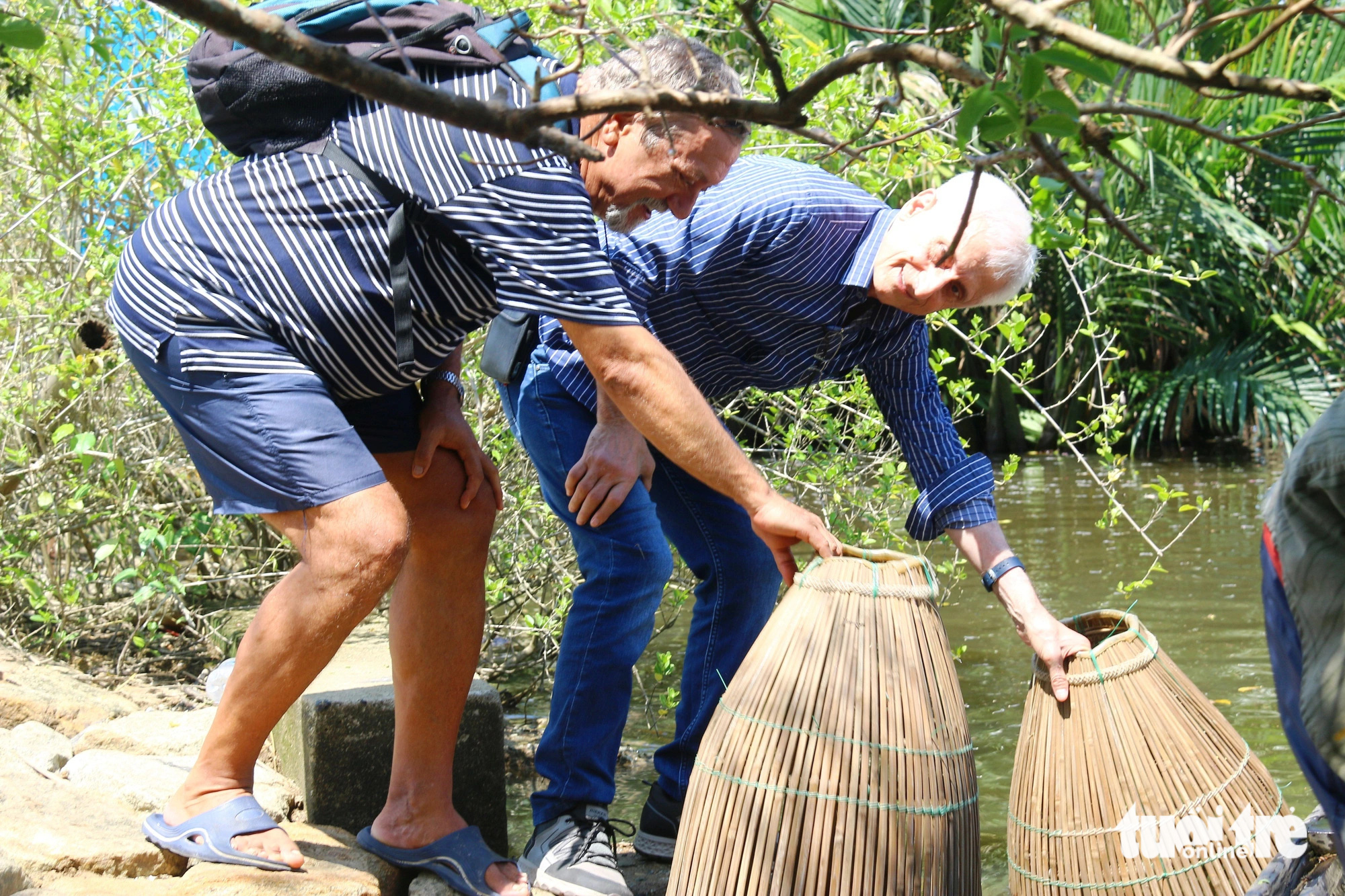 Foreign tourists try their hand at fishing with local tools in the Ru Cha primeval mangrove forest in the Tam Giang - Cau Hai lagoon, located in Thua Thien-Hue Province in central Vietnam. Photo: Nhat Linh / Tuoi Tre