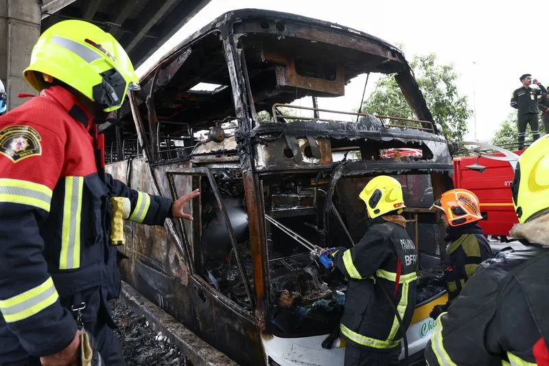 Firefighters work to extinguish a burning bus that was carrying teachers and students from Wat Khao Phraya school, reportedly killing almost a dozen, on the outskirts of Bangkok, Thailand, October 1, 2024. Photo: Reuters