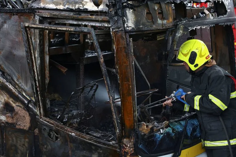 Firefighter works to extinguish a burning bus that was carrying teachers and students from Wat Khao Phraya school, reportedly killing almost a dozen, on the outskirts of Bangkok, Thailand, October 1, 2024. Photo: Reuters