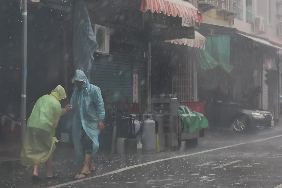 Two people help each other walk as Typhoon Krathon approaches, in Kaohsiung, Taiwan October 3, 2024. Photo: Reuters