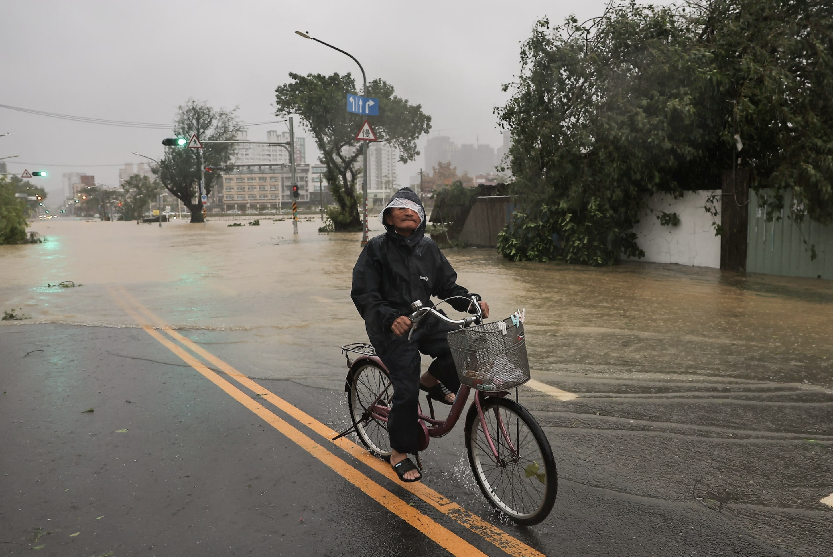 A person rides his bicycle on a flooded road after Typhoon Krathon made landfall in Kaohsiung, Taiwan October 3, 2024. Photo: Reuters