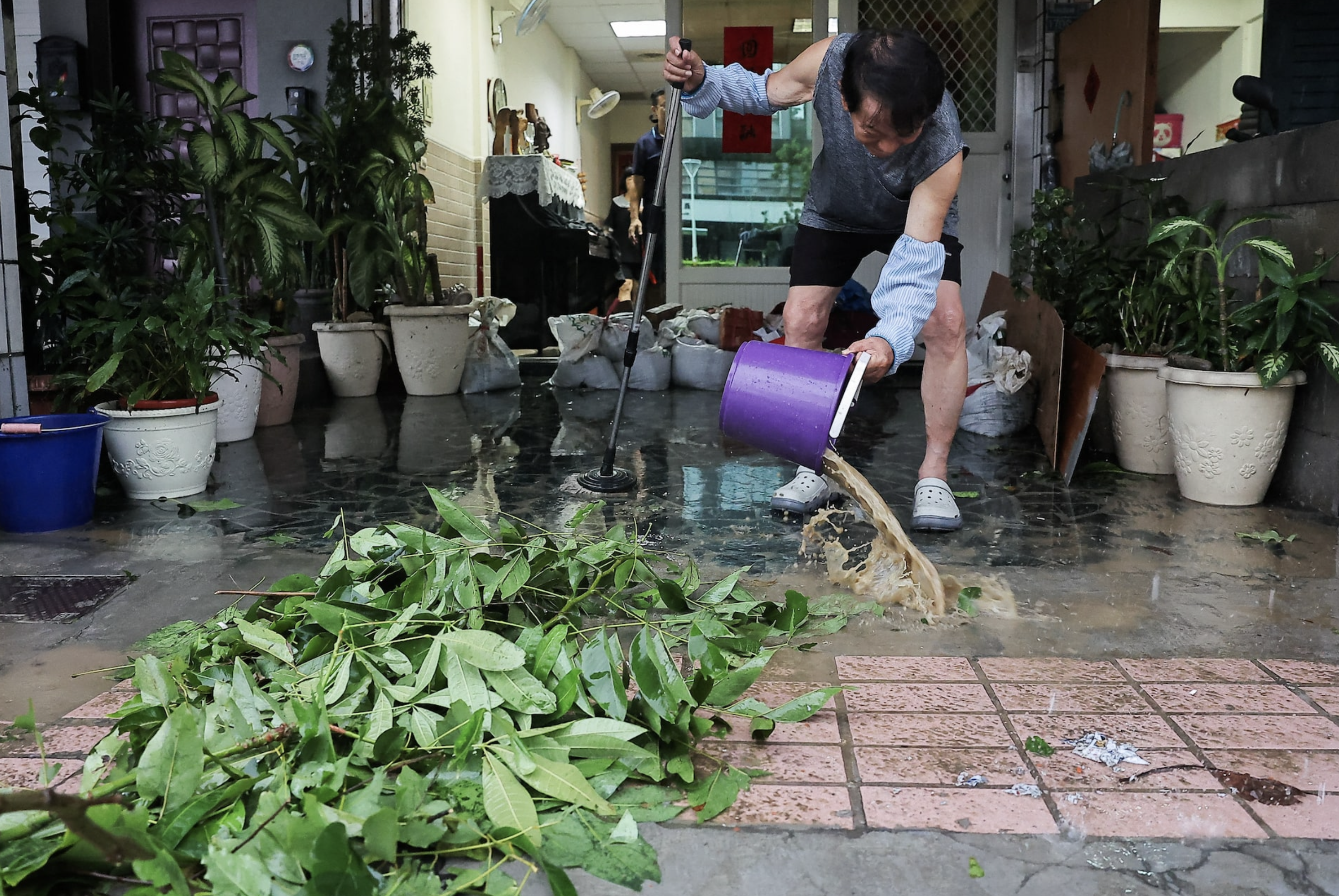 A man cleans the flood inside his home after Typhoon Krathon made landfall in Kaohsiung, Taiwan October 3, 2024. Photo: Reuters