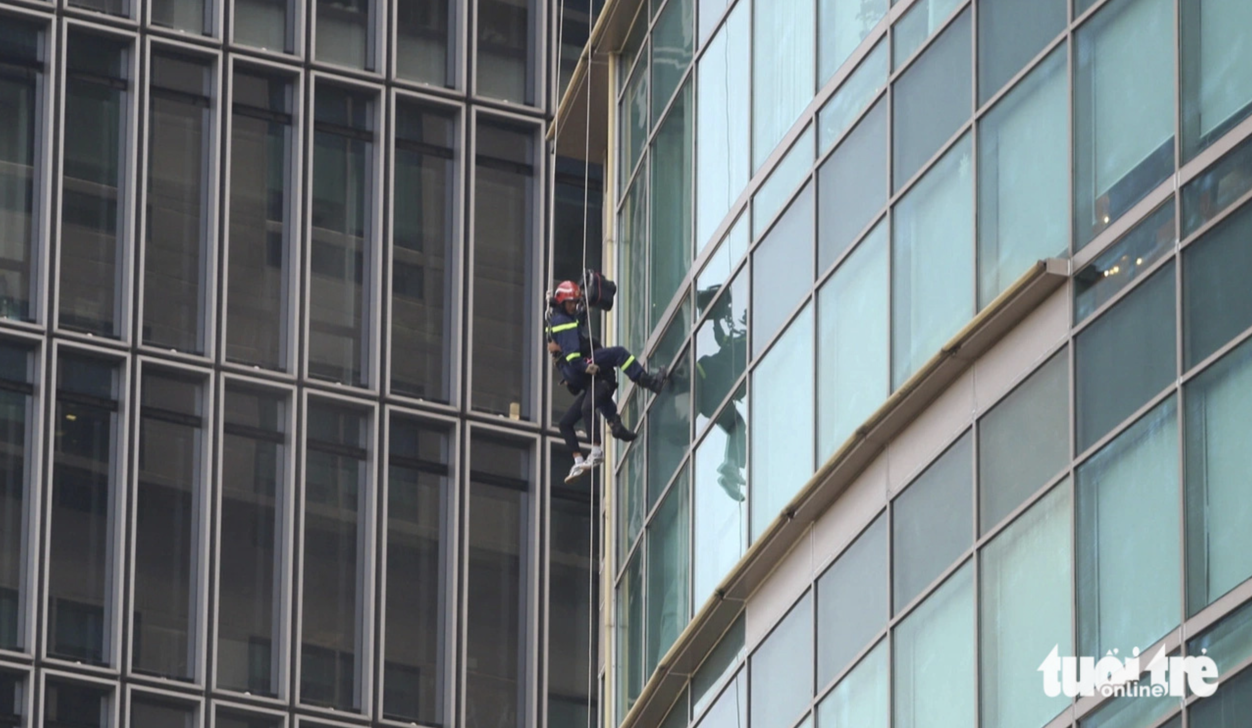 Firefighters use a system of ropes and pulleys to approach the top floor of the mPlaza Saigon building to rescue trapped victims during a fire drill in Ho Chi Minh City on October 4, 2024. Photo: Minh Hoa / Tuoi Tre