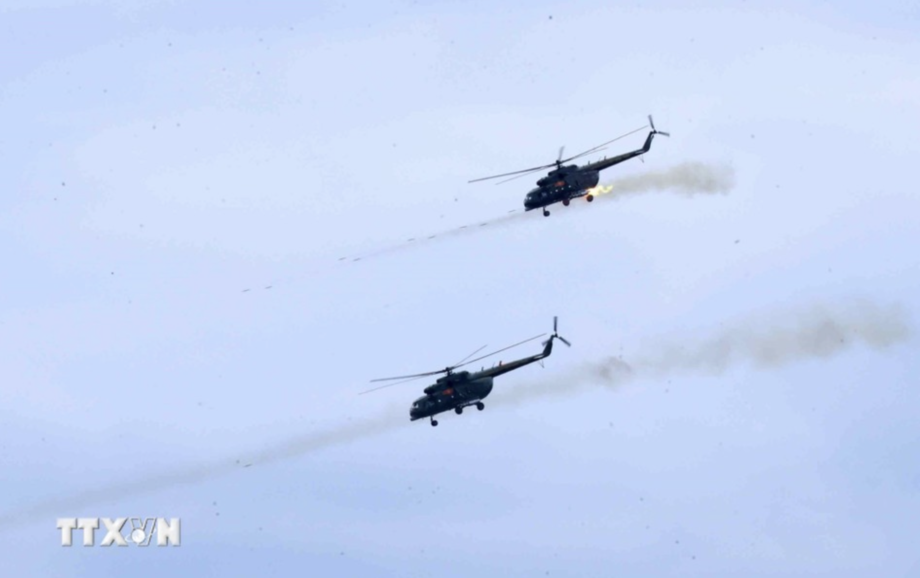 Two Mi-17 helicopters head to targets, firing rocket rounds to destroy them. Photo: Vietnam News Agency