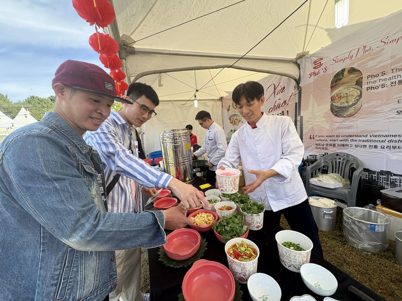 Tran Van Hien (first from left) and Pham Duong (second from left) pay attention when chef Le Duc Huy and Nguyen Tien Hai, who previously won Golden Star Anise awards for best phờ chefs, explain to them how to cook phở with Ngoc Linh ginseng at the Vietnam Phở Festival 2024 in Seoul on October 5, 2024. Photo: Duyen Phan / Tuoi Tre News