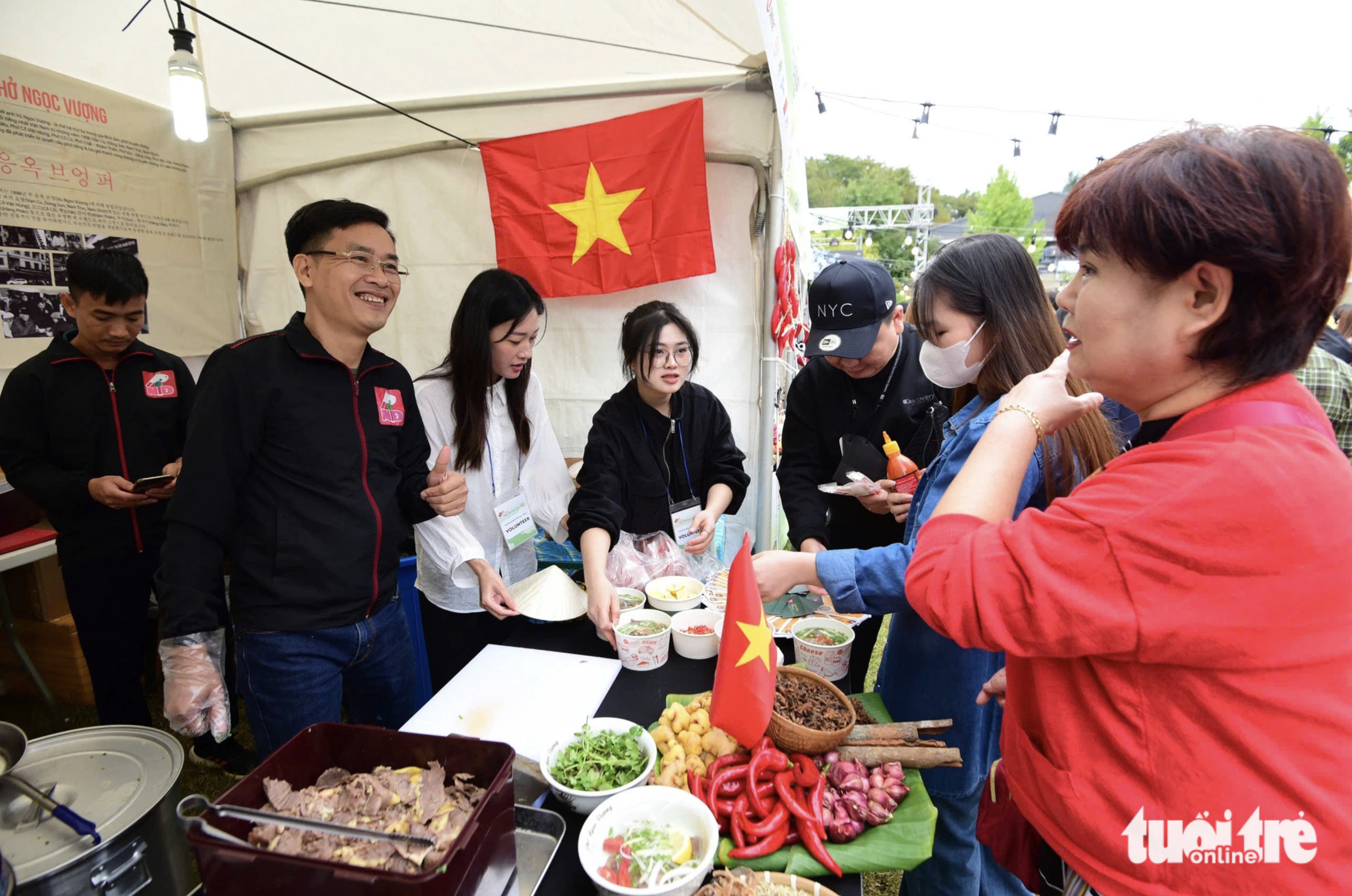 Visitors wait for a bowl of phở at the Phở Ngoc Vuong stall