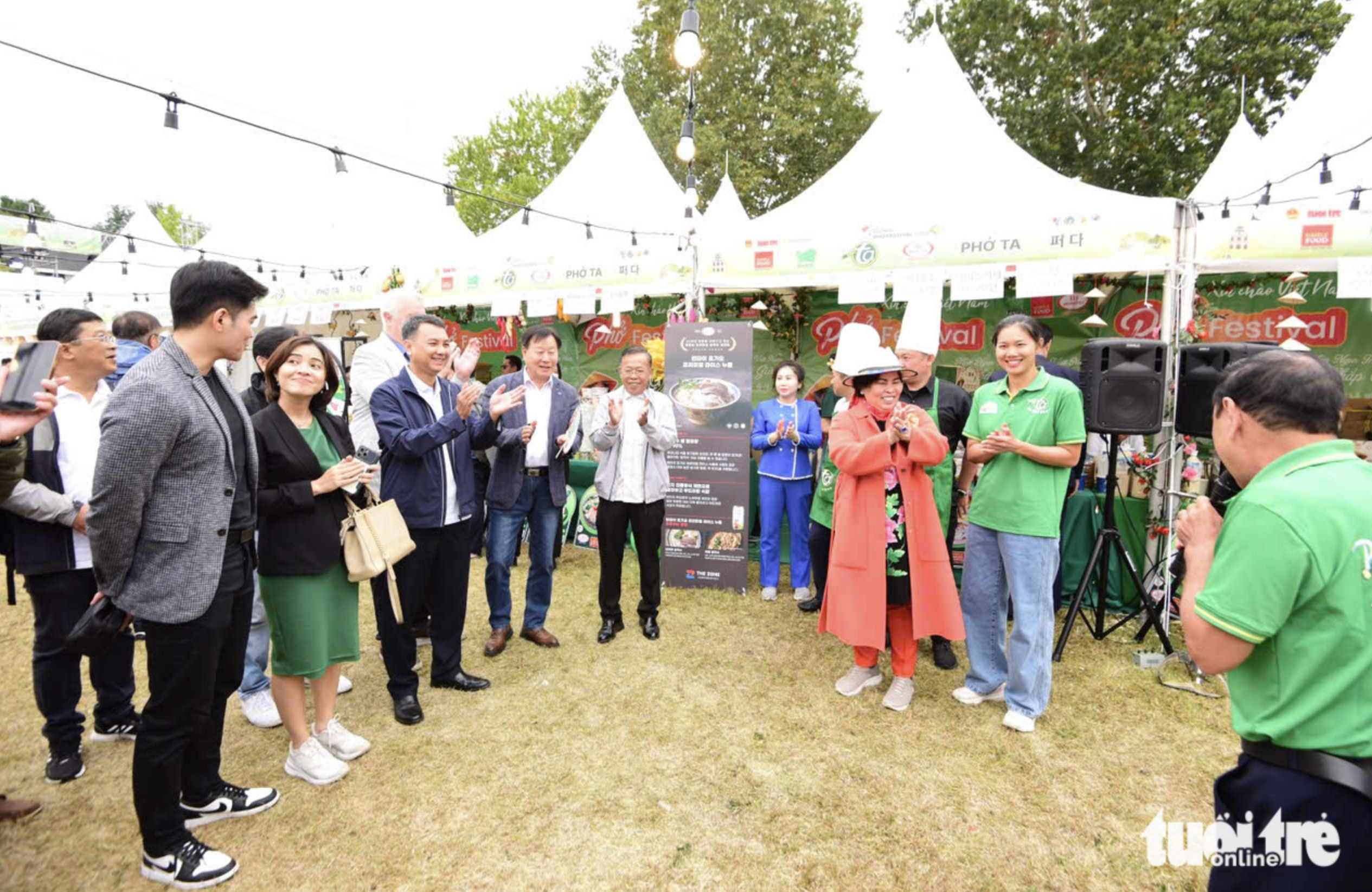 Swimmer Anh Vien, artisan Mai Dinh Toi and some visitors gather at ther stall of the Phở Ta - Binh Tay Food