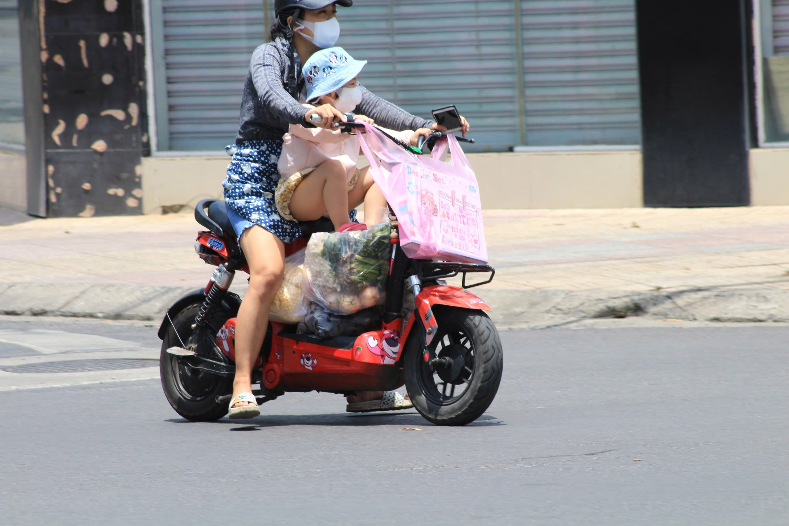 A woman is seen carrying a child on her vehicle in this photo taken in Ho Chi Minh City. Photo: Ray Kuschert