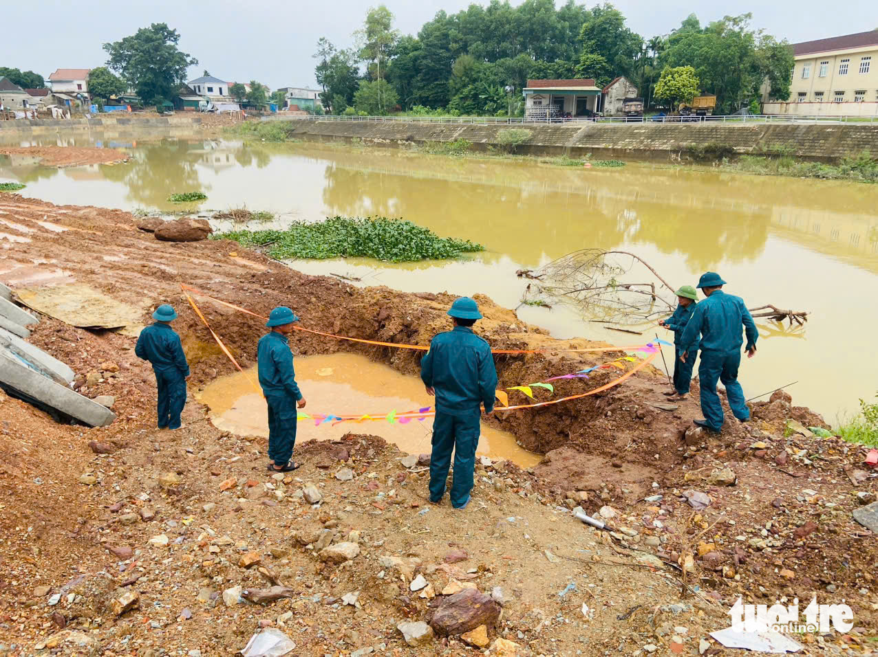 Military officers guard the site where a war-time bomb was uncovered in Ha Tinh Province, north-central Vietnam. Photo: Le Minh / Tuoi Tre