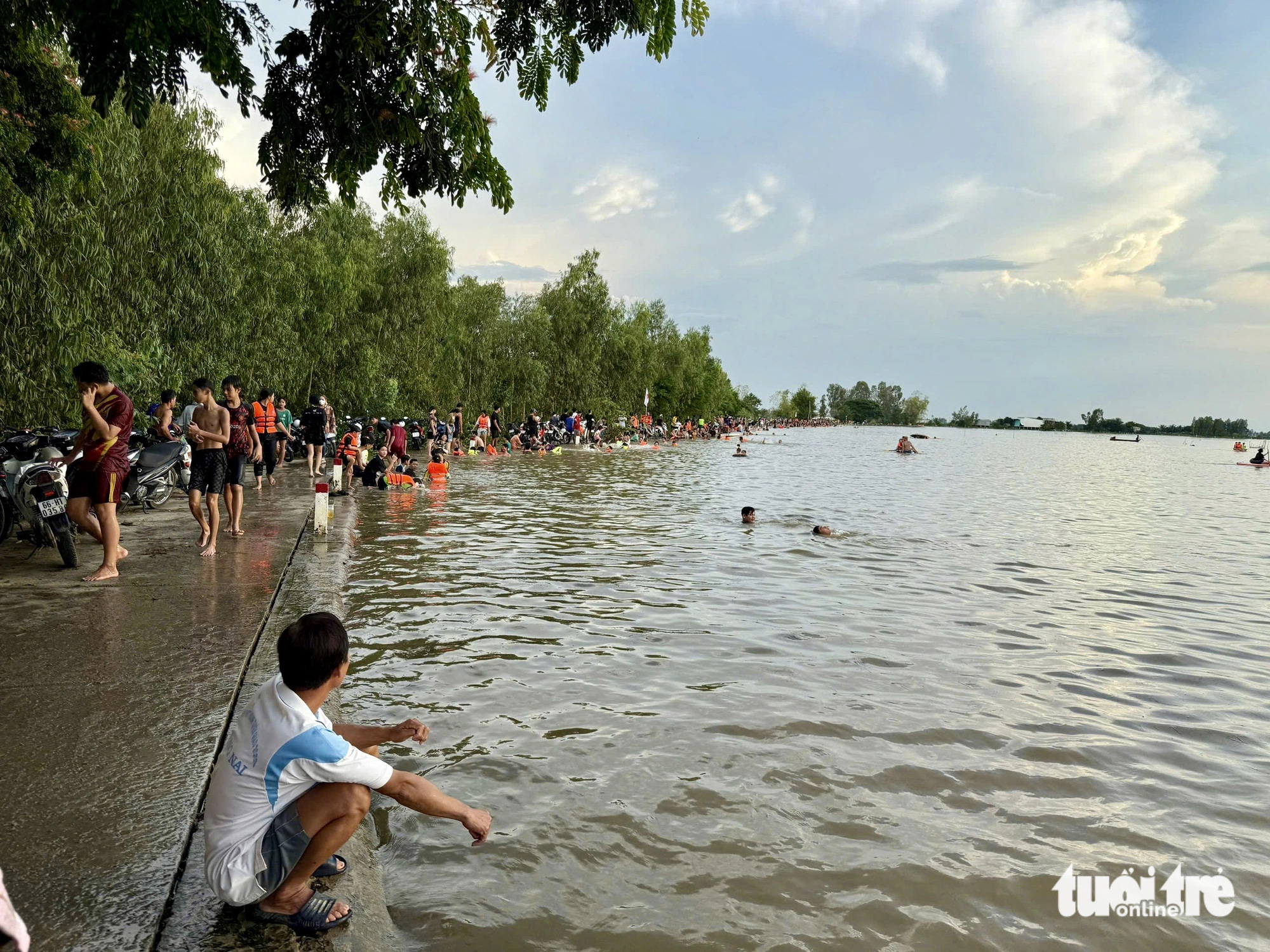 A man monitors his children swimming in the flooded fields of Hong Ngu District, Dong Thap Province, southern Vietnam, October 10, 2024. Photo: Tong Doanh / Tuoi Tre