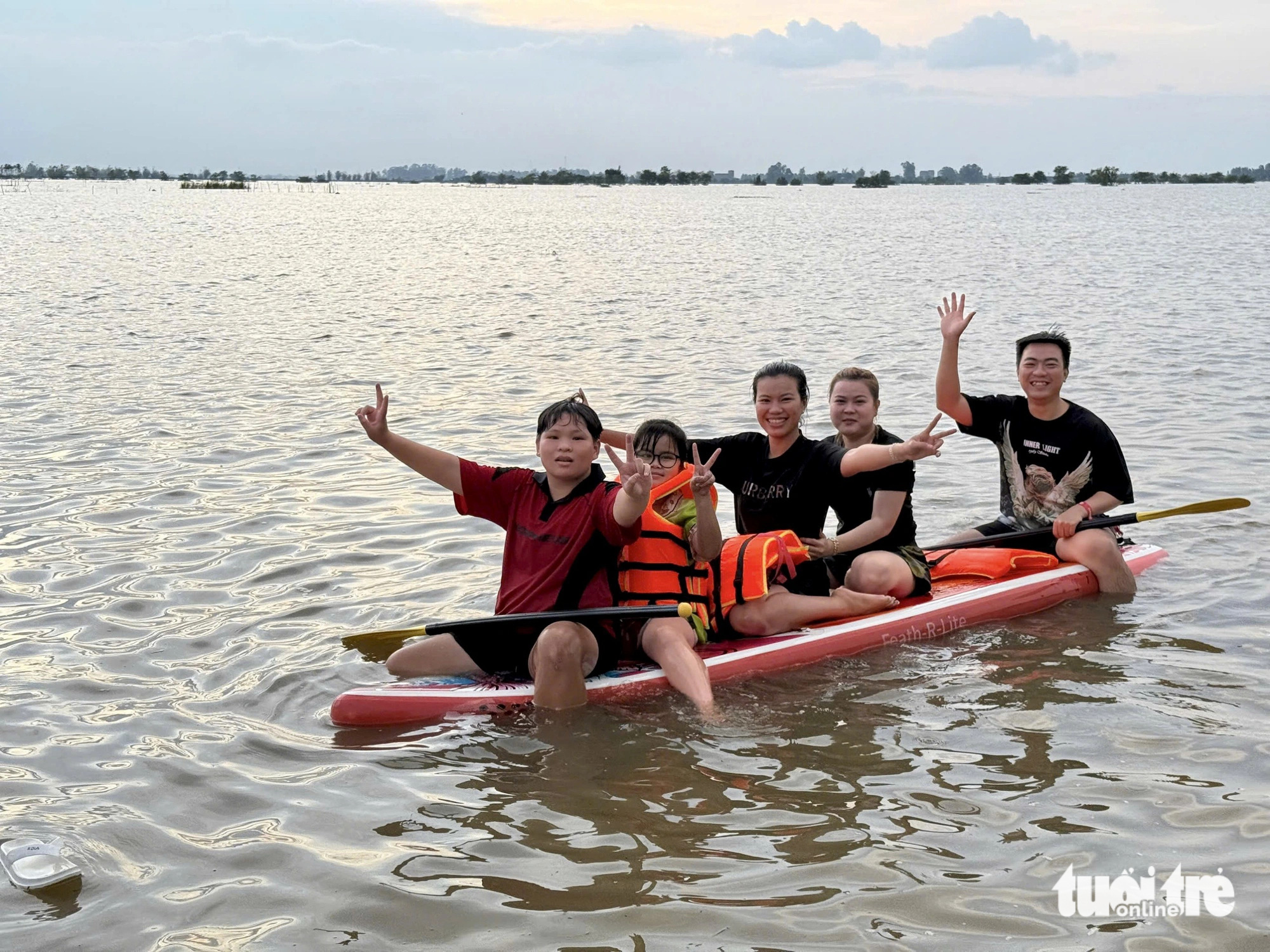 Children and adults row a stand-up paddle board in the expansive flooded fields of Hong Ngu District, Dong Thap Province, southern Vietnam, October 10, 2024. Photo: Tong Doanh / Tuoi Tre