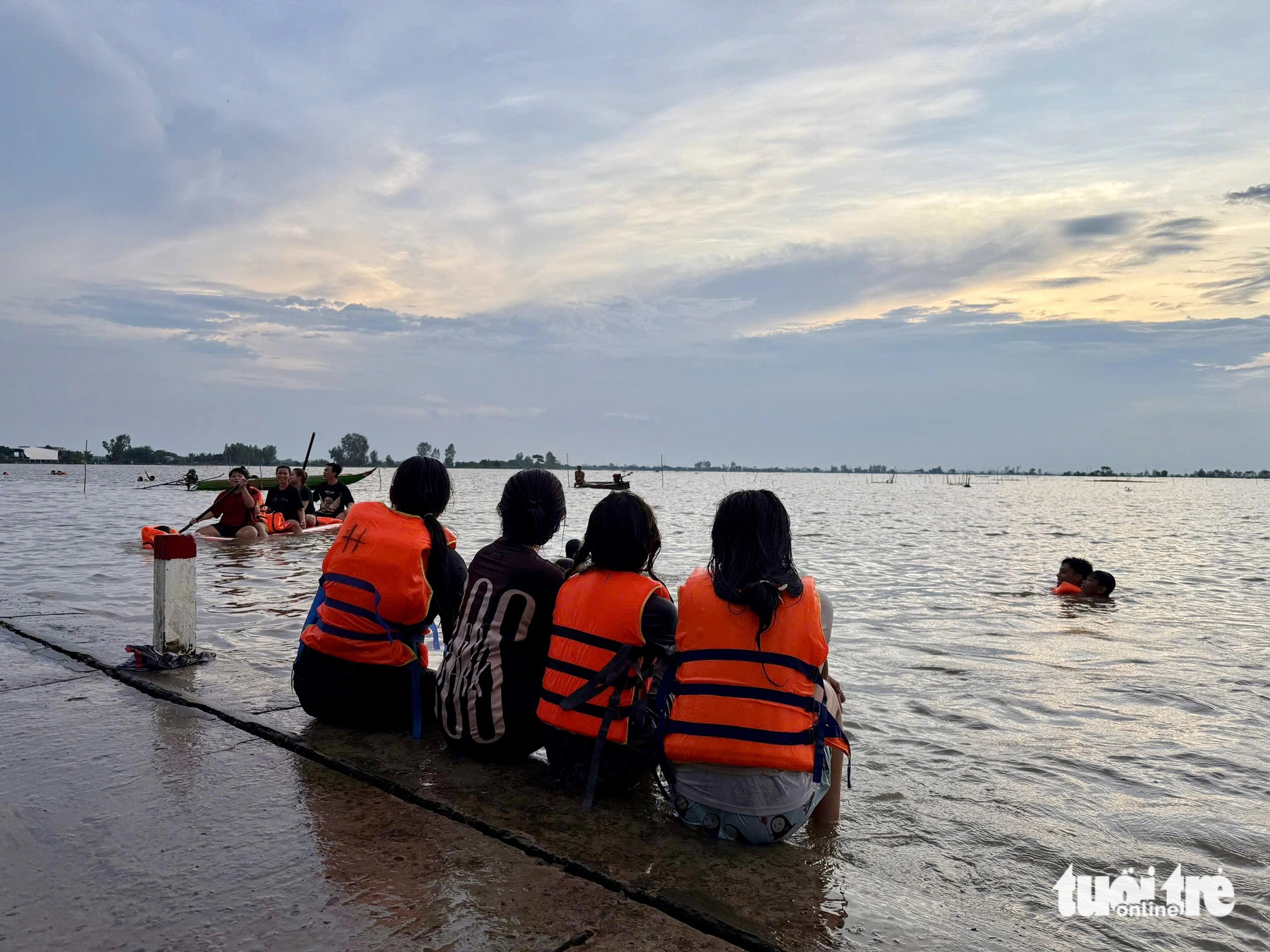 Children watch people swimming in the expansive flooded fields in Hong Ngu District, Dong Thap Province, southern Vietnam, October 10, 2024. Photo: Tong Doanh / Tuoi Tre