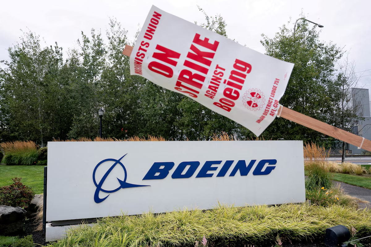 A strike sign hangs from a post near a Boeing sign as Boeing factory workers and supporters gather on a picket line during the third day of a strike near the entrance to a Boeing production facility in Renton, Washington, U.S. September 15, 2024. Photo: Reuters