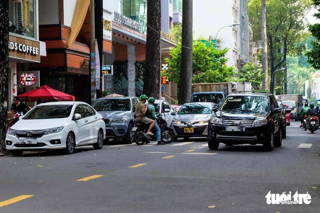 Cars are sometimes parked into two lines on Bui Thi Xuan Street in District 1, Ho Chi Minh City, forcing other vehicles to encroach on the wrong lanes to pass through the street. Photo: Phuong Nhi / Tuoi Tre