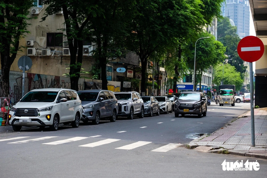 Many cars occupy part of the roadbed of a street in Ho Chi Minh City. Photo: Phuong Nhi / Tuoi Tre