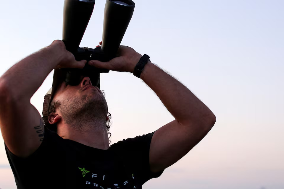 [6/8]A man looking through binoculars as people gather to observe the launch of SpaceX's Starship during its fifth flight test, in Boca Chica, Texas, U.S., October 13, 2024. Photo: Reuters