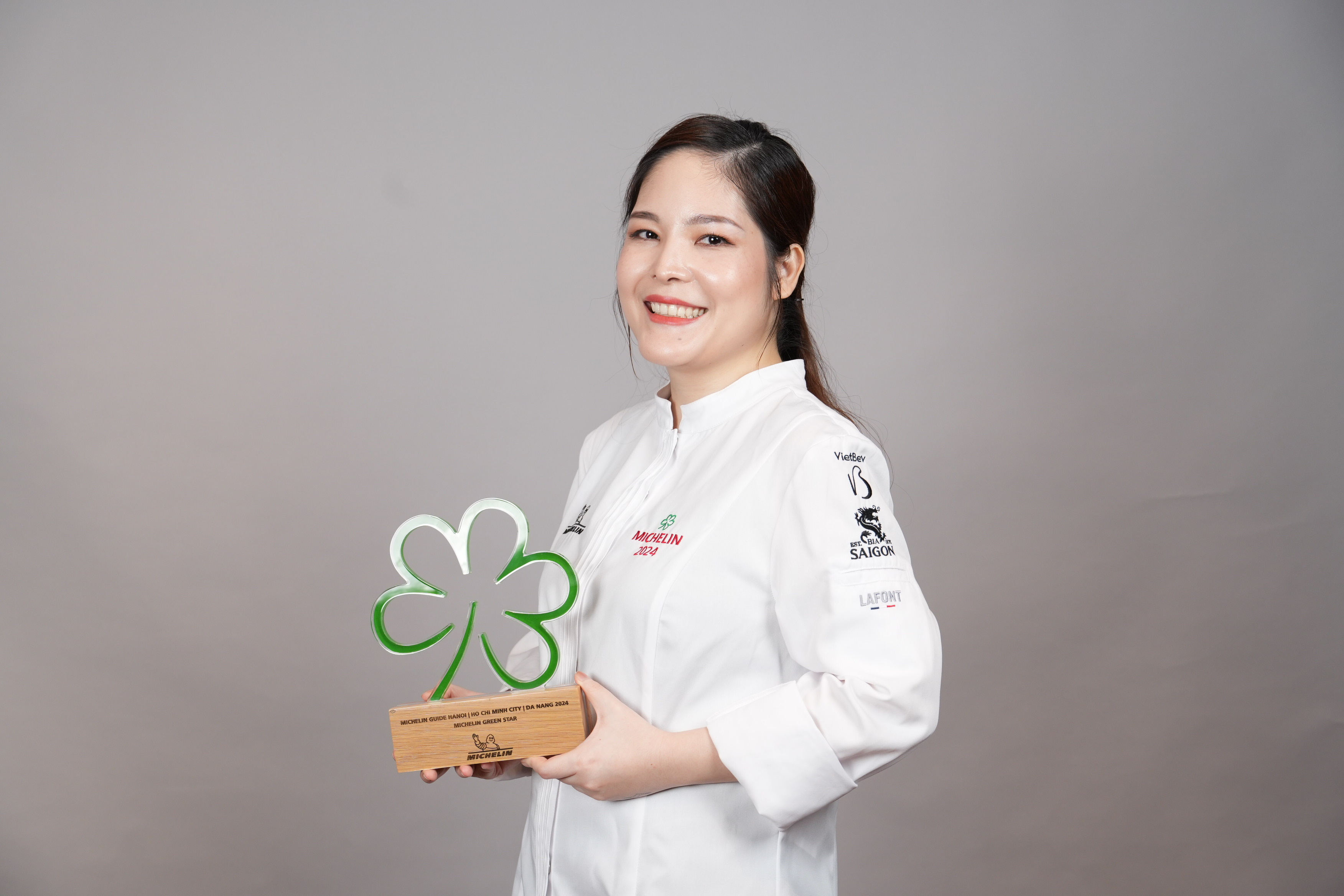 Summer Le, founder and executive chef of Nén Danang and Nén Light Saigon, poses for a photo with the Green Michelin Star awarded to Nén Danang in June 2024. Photo by courtesy of Summer Le