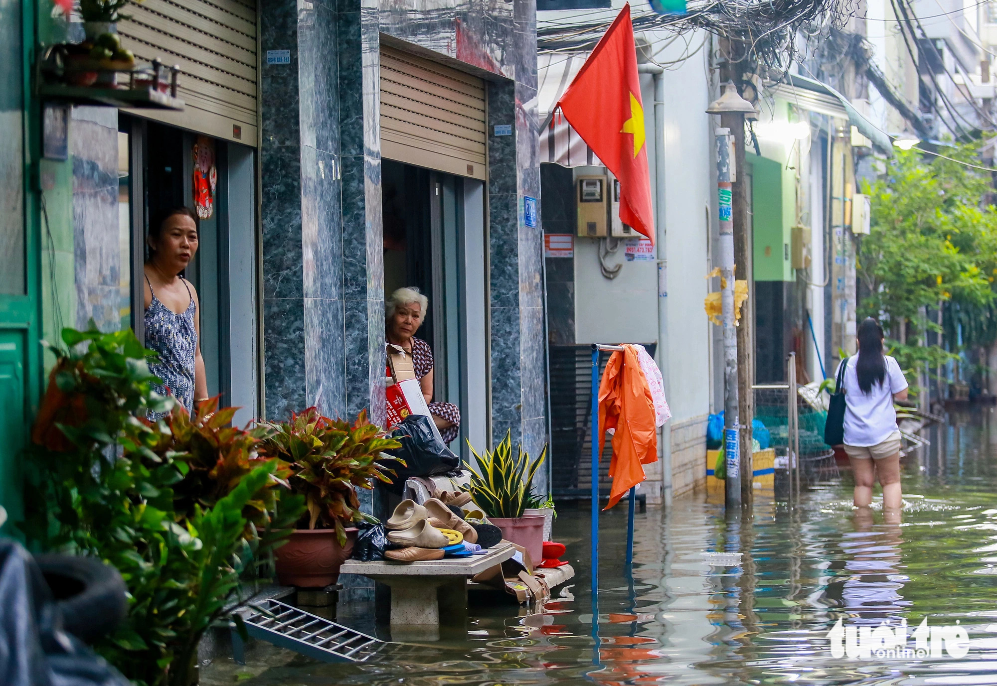 Residents look out from their houses down the flooded Alley 67 on Bui Van Ba Street in District 7, Ho Chi Minh City, October 18, 2024. Photo: Le Phan / Tuoi Tre