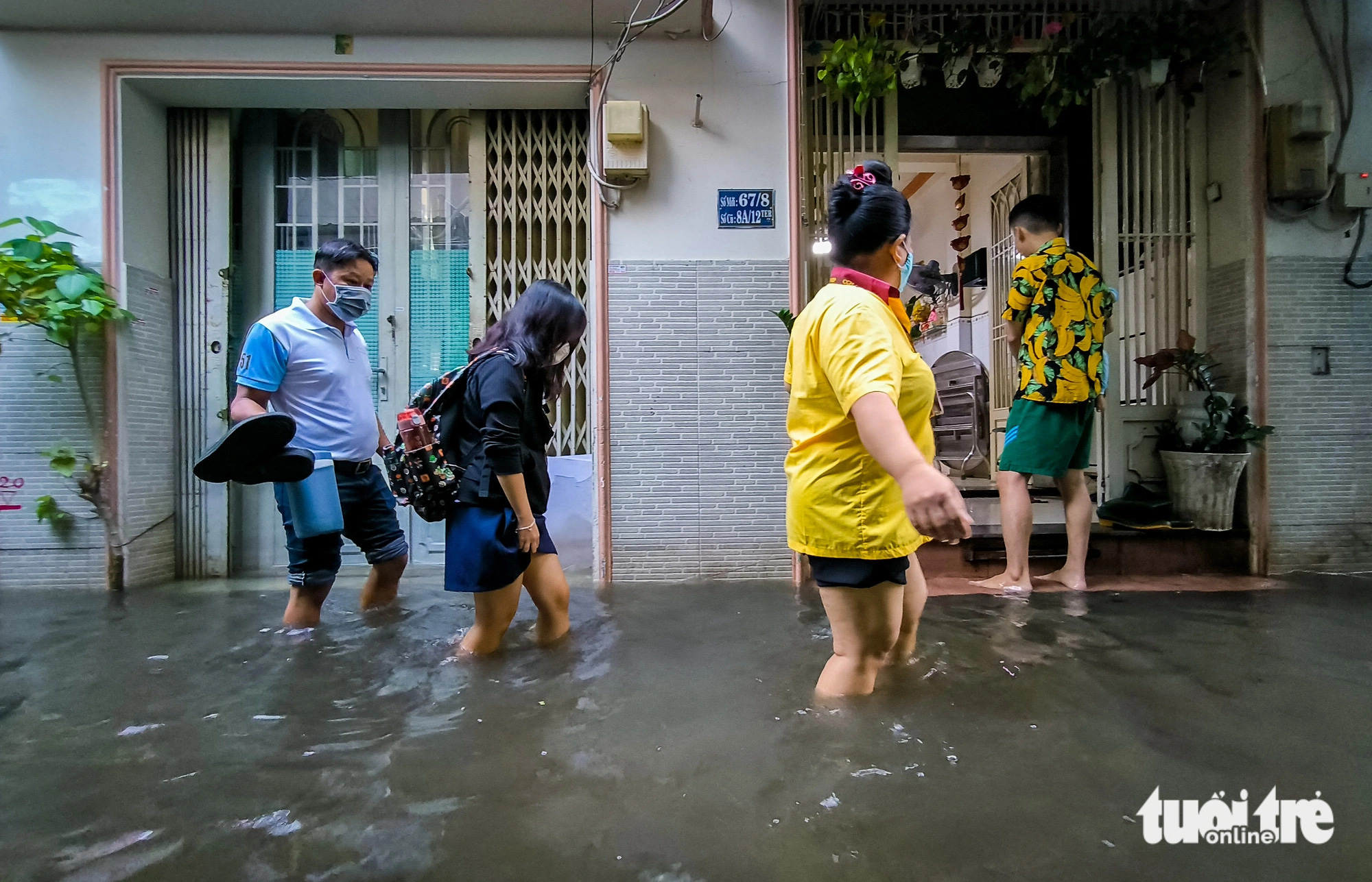 People wade through floodwaters down Alley 67 on Bui Van Ba Street in District 7, Ho Chi Minh City, October 18, 2024. Photo: Chau Tuan / Tuoi Tre