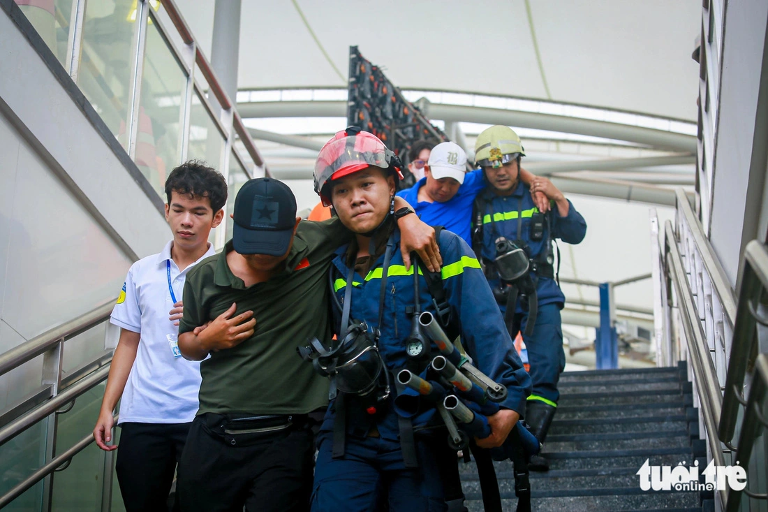 Firefighters evacuate passengers to safety. Photo: Chau Tuan / Tuoi Tre