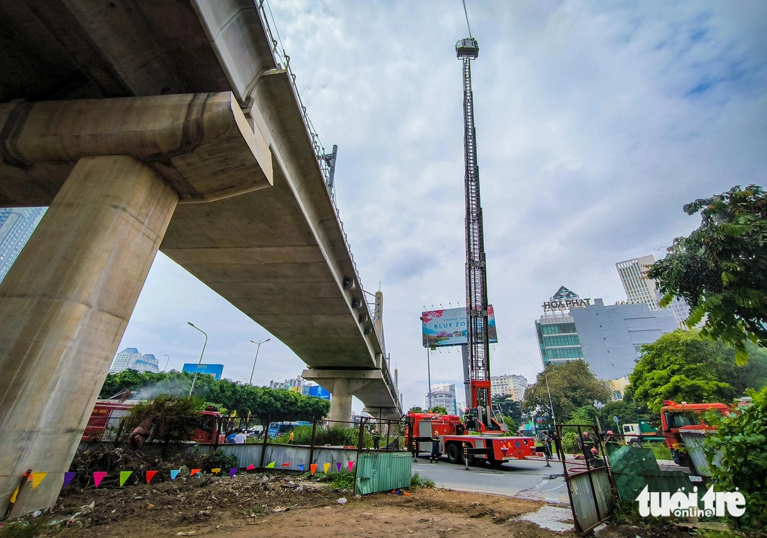 Firefighters use a ladder truck to access the elevated track to put out the fire and save passengers. Photo: Chau Tuan / Tuoi Tre