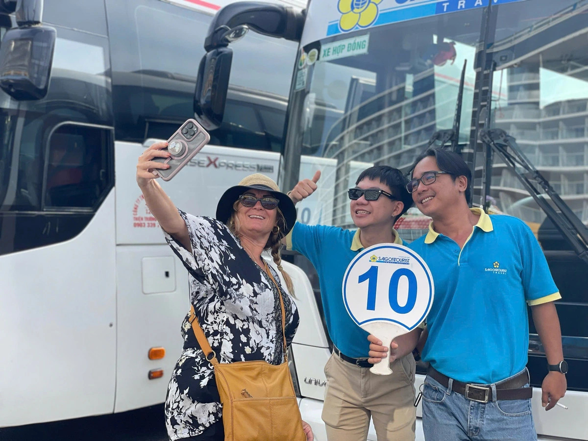 A female tourist takes a selfie photo with two staff of Vietnam’s leading tour operator Saigontourist who welcomed her upon her arrival in Vietnam. Photo: H.L. / Tuoi Tre