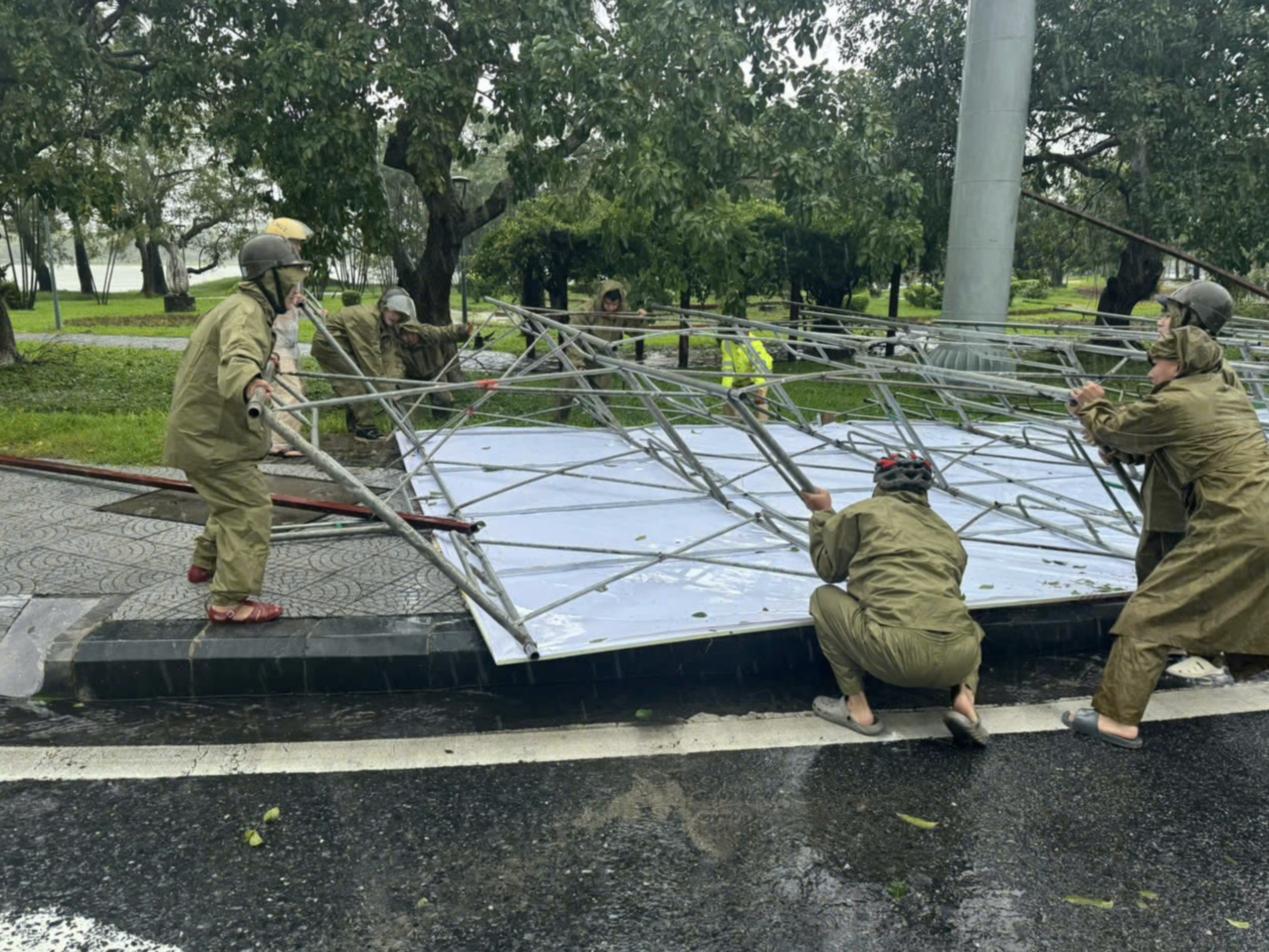 A billboard collapses on a street in Hue City. Photo: Tran Hong / Tuoi Tre