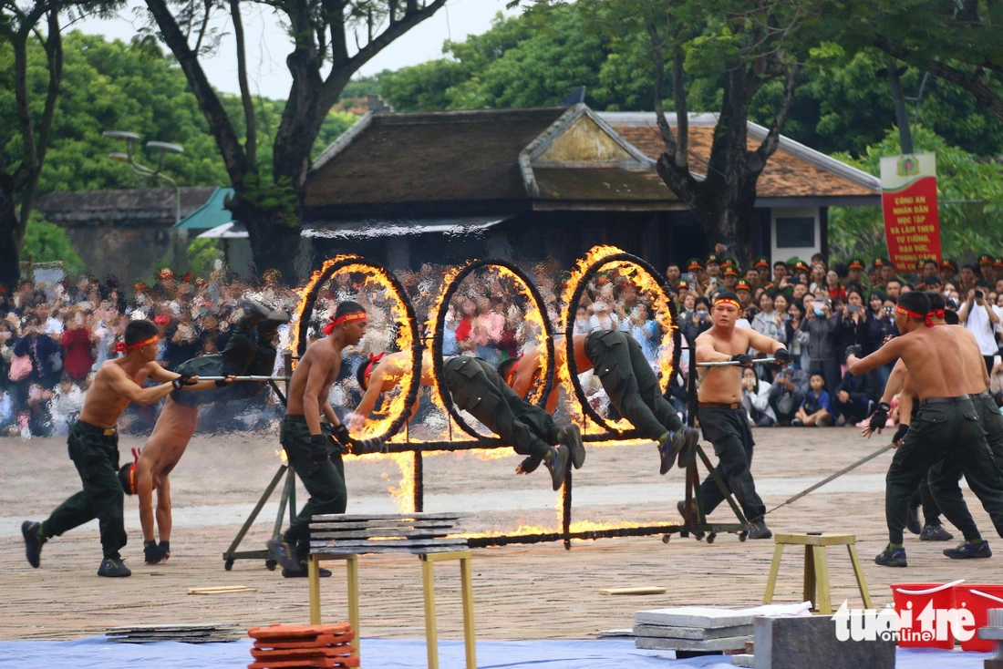 Police officers jump over rings of fire in Thua Thien-Hue Province, October 26, 2024. Photo: Nhat Linh / Tuoi Tre