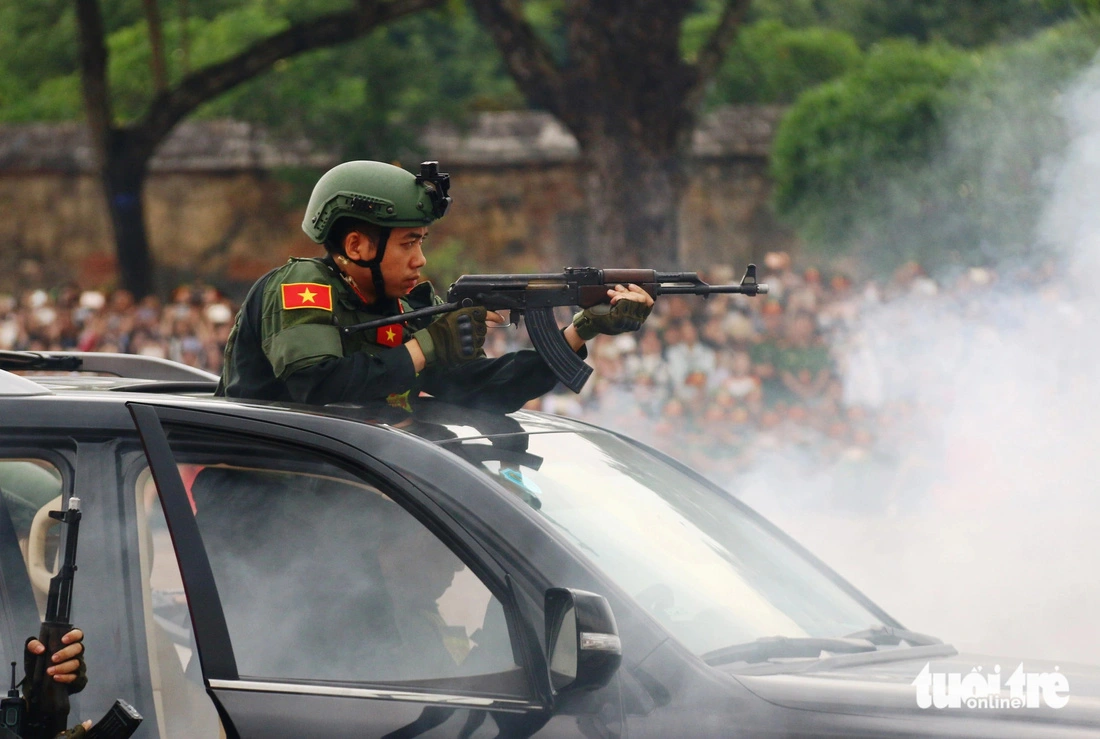 A police officer fires a weapon to protect a foreign VIP guest from terrorists in a drill during the opening ceremony of the ‘Health for National Security’ campaign in Thua Thien-Hue Province, October 26, 2024. Photo: Nhat Linh / Tuoi Tre