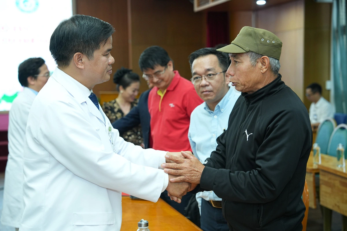 Dao Xuan Co (L), director of Bach Mai Hospital, holds the hands of a family member of the organ donor. Photo: Supplied