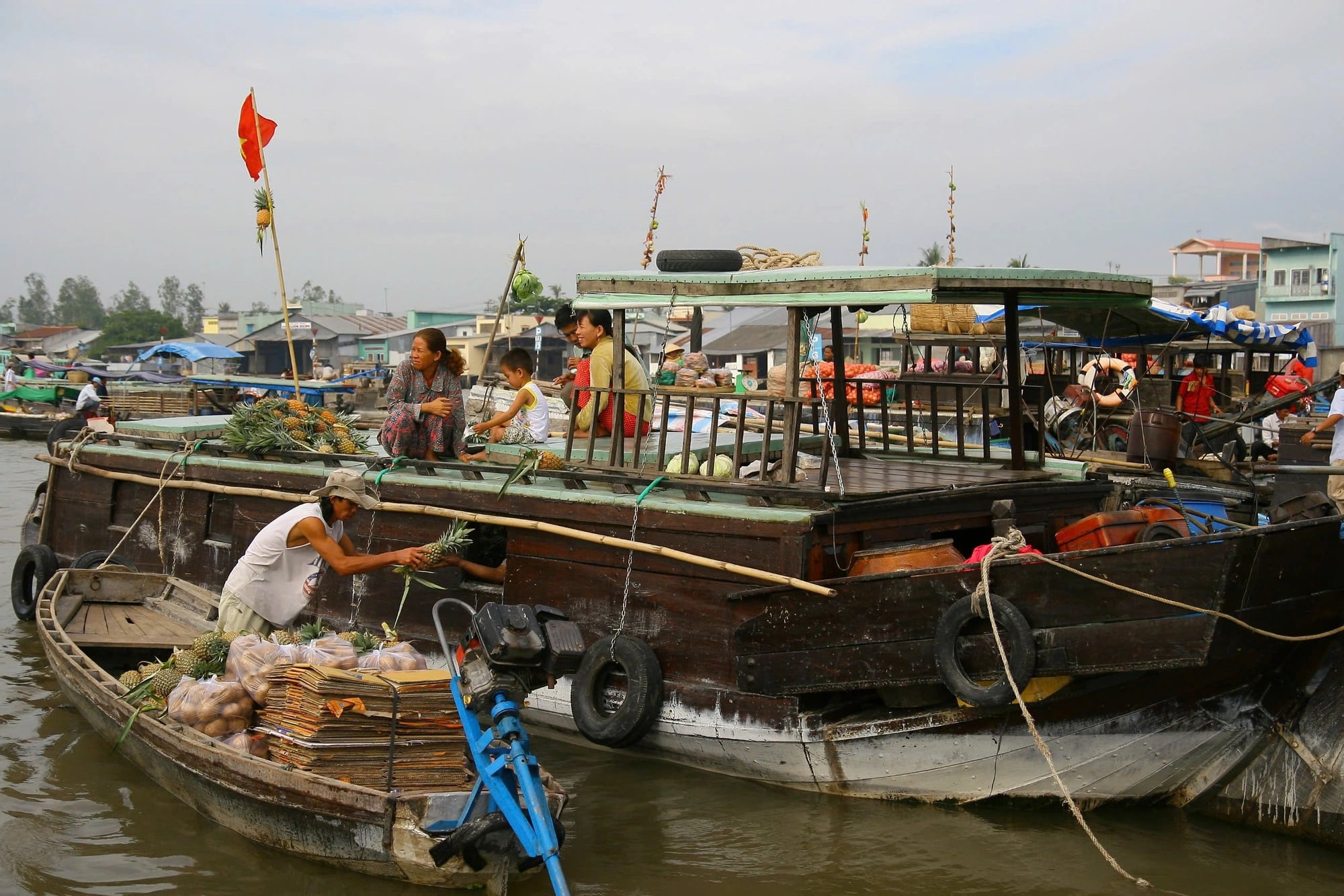 A pineapple is hung on the roof of a boat as an advertisement of what’s for sale.