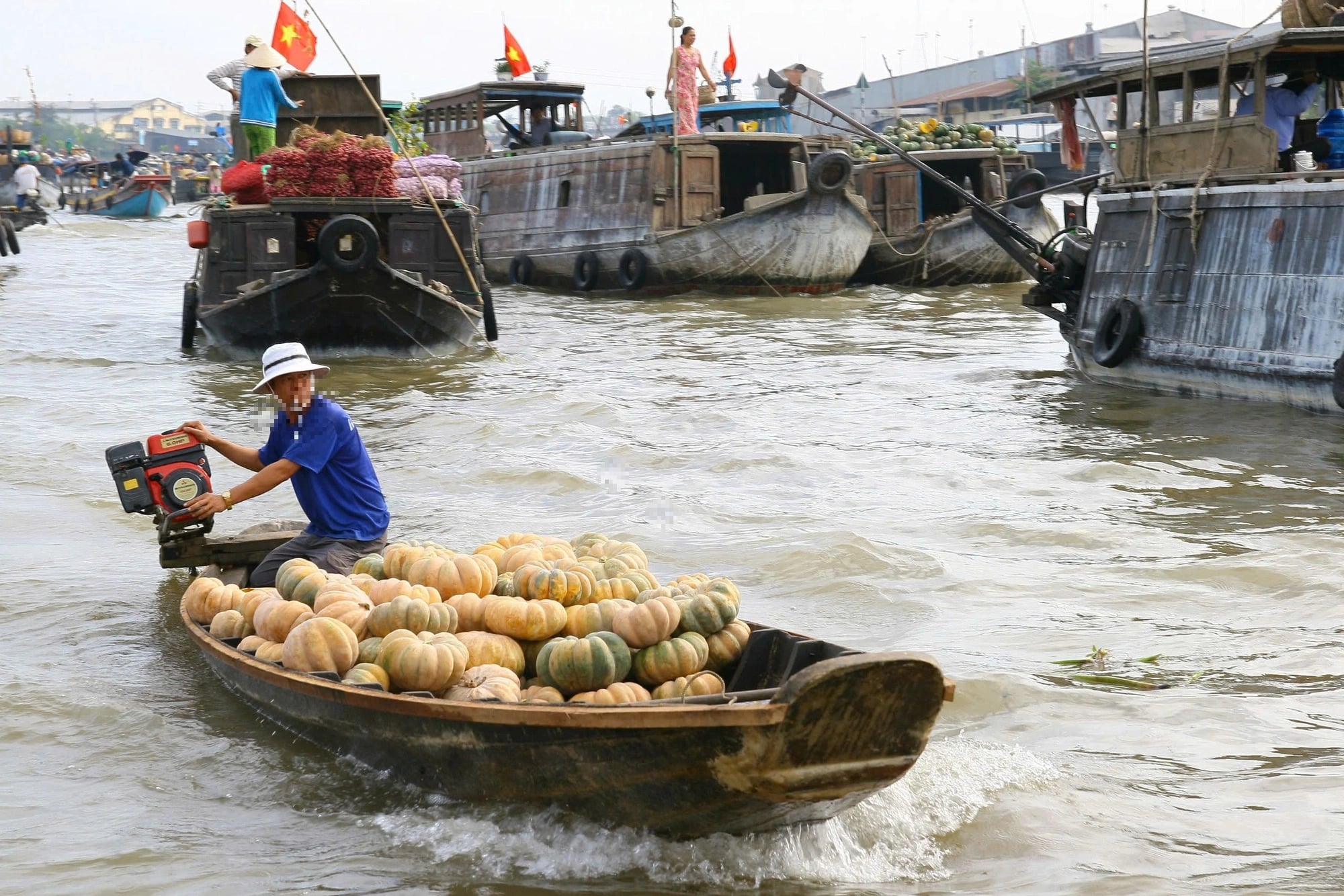 A trader operates a motorboat to transport goods to the marketplace.