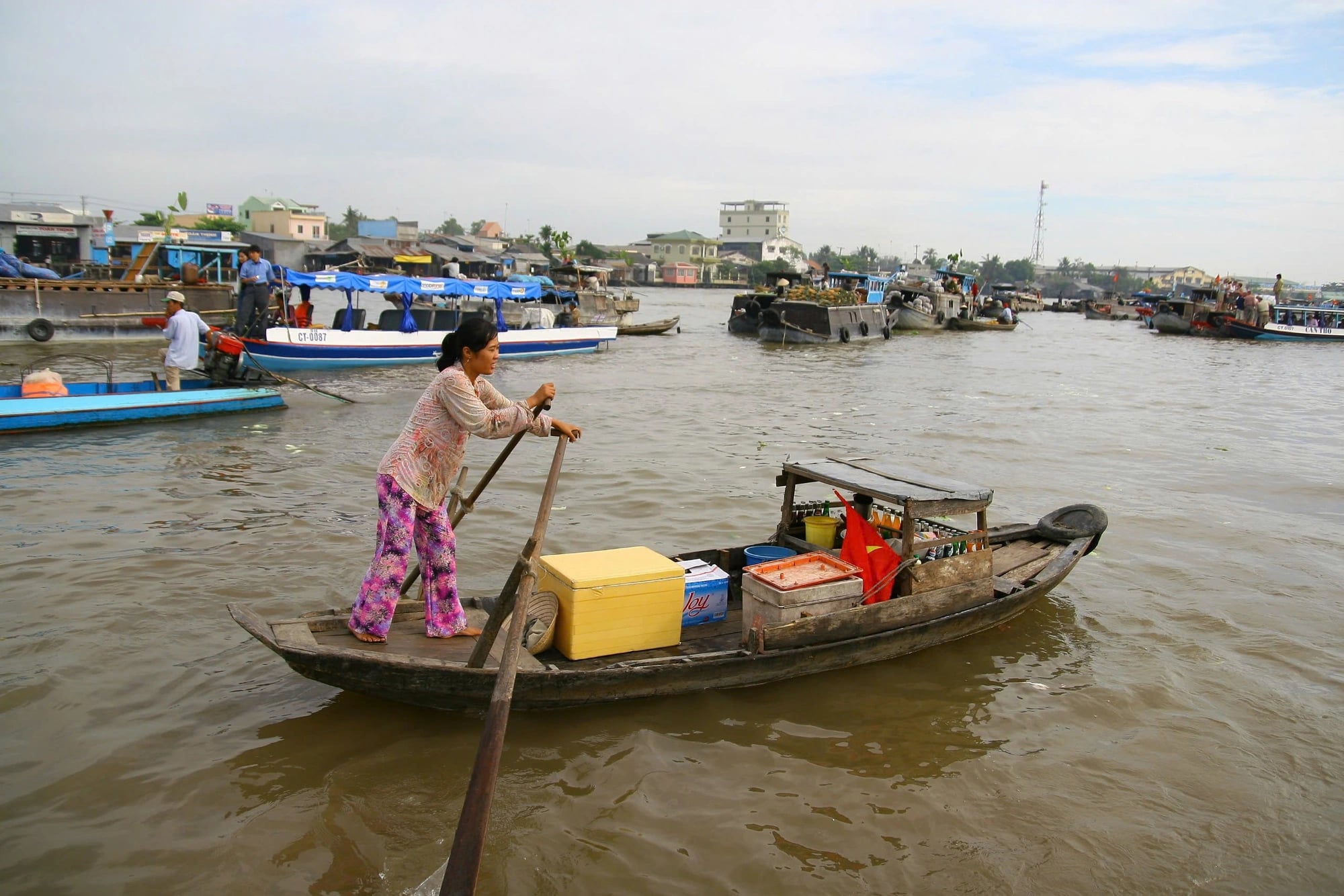 A boat serves food and beverages to traders at a floating market.