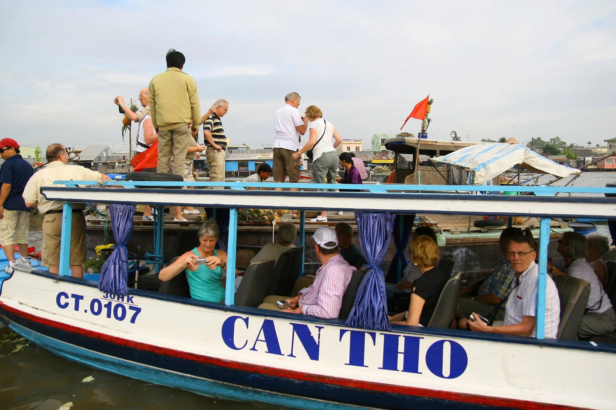 Tourists visit a bustling floating market in Mekong Delta.