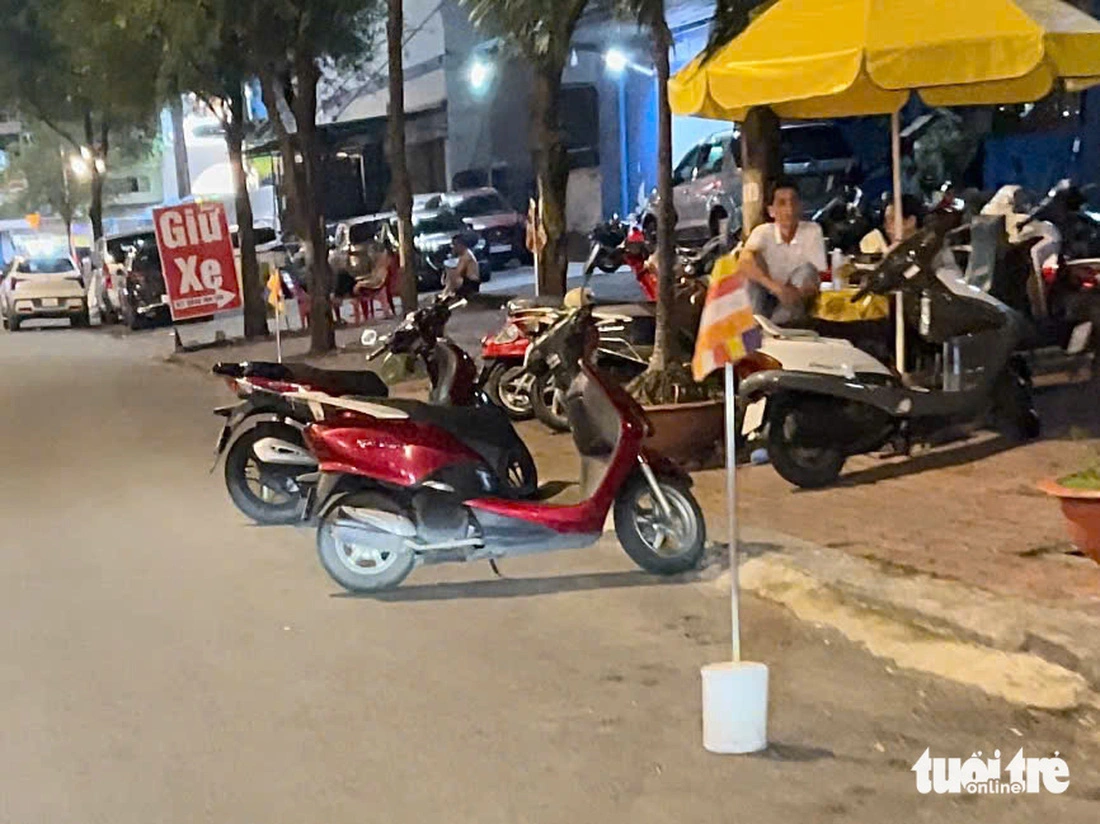 A parking service provider puts concrete blocks on the street and sidewalk along Dao Duy Tu Street in District 10, Ho Chi Minh City to save space for customer parking. Photo: Dieu Qui / Tuoi Tre