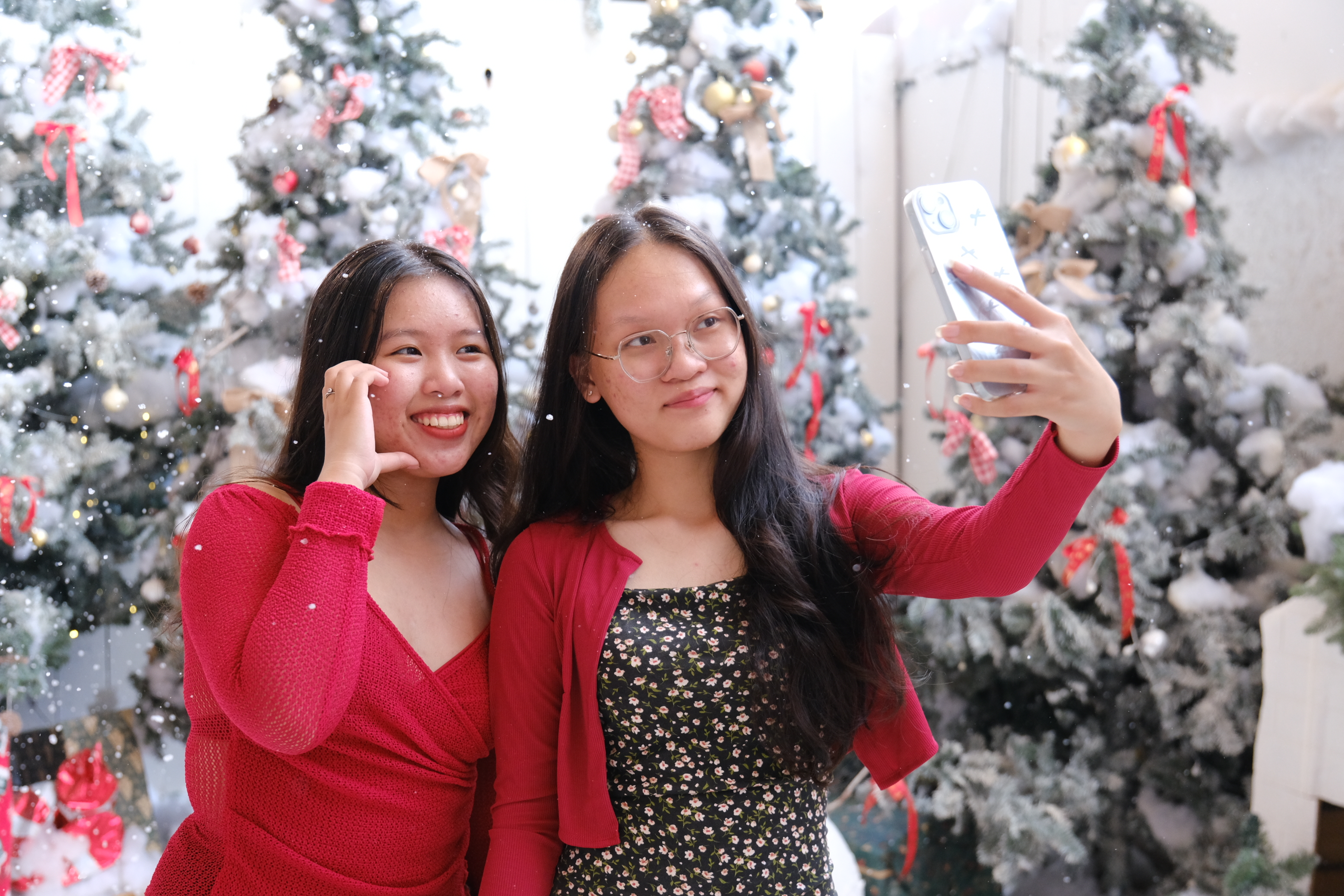 Two visitors take selfies at the Christmas-themed restaurant. Photo: Ngoc Phuong / Tuoi Tre News