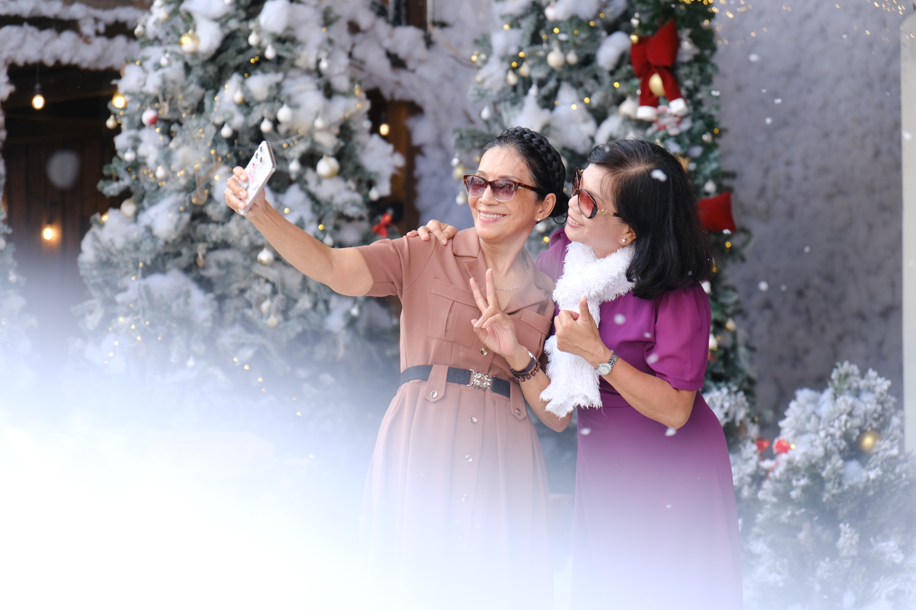 Two visitors take selfies at the Christmas-themed restaurant. Photo: Ngoc Phuong / Tuoi Tre News