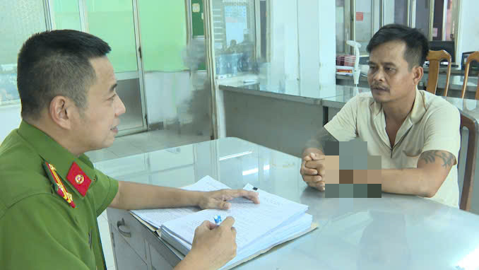 A police officer questions Nguyen Anh Phong (R), a 37-year-old hotel housekeeper from the Mekong Delta province of Ben Tre, at the police station in District 1, Ho Chi Minh City. Photo: Supplied