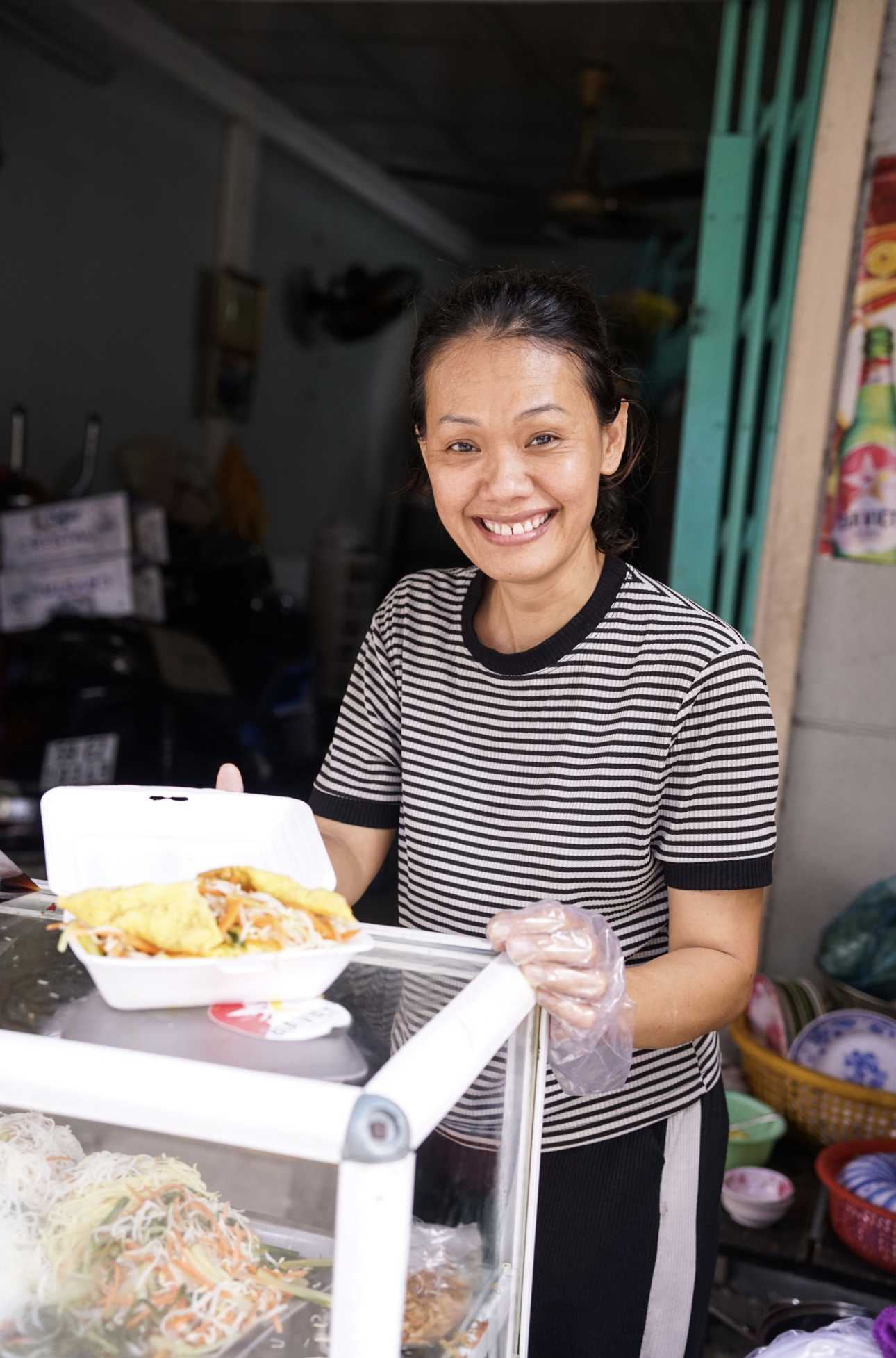 The owner of an eatery at a market on Tran Khac Chan Street in the trackside village in Phu Nhuan District looks at the camera and smiles. Photo: Nguyen Quach Phuong Thao