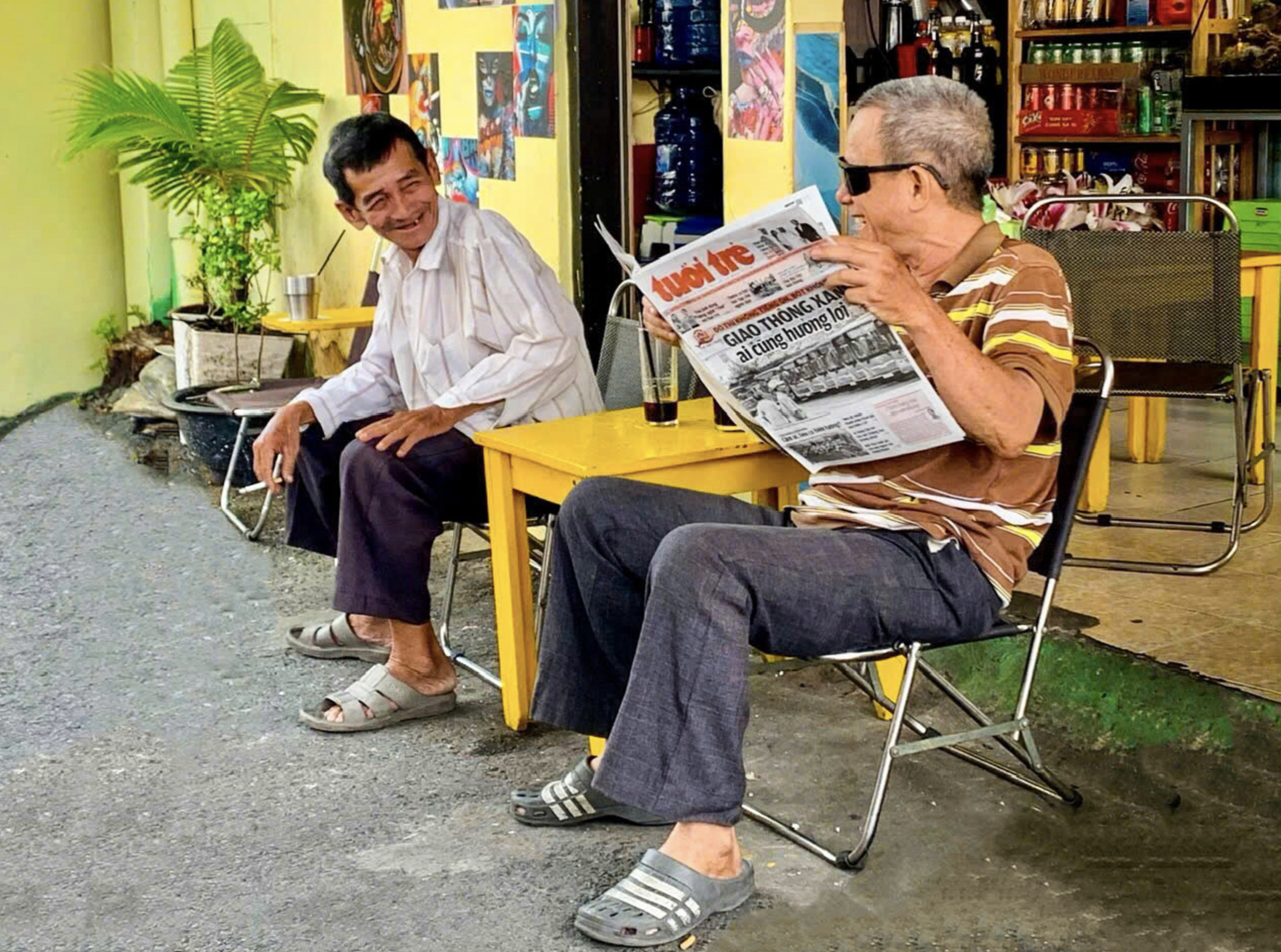 Two old men in the trackside village are pictured chatting and reading Tuoi Tre (Youth) newspaper. Photo: Vo Le Tuong Vi