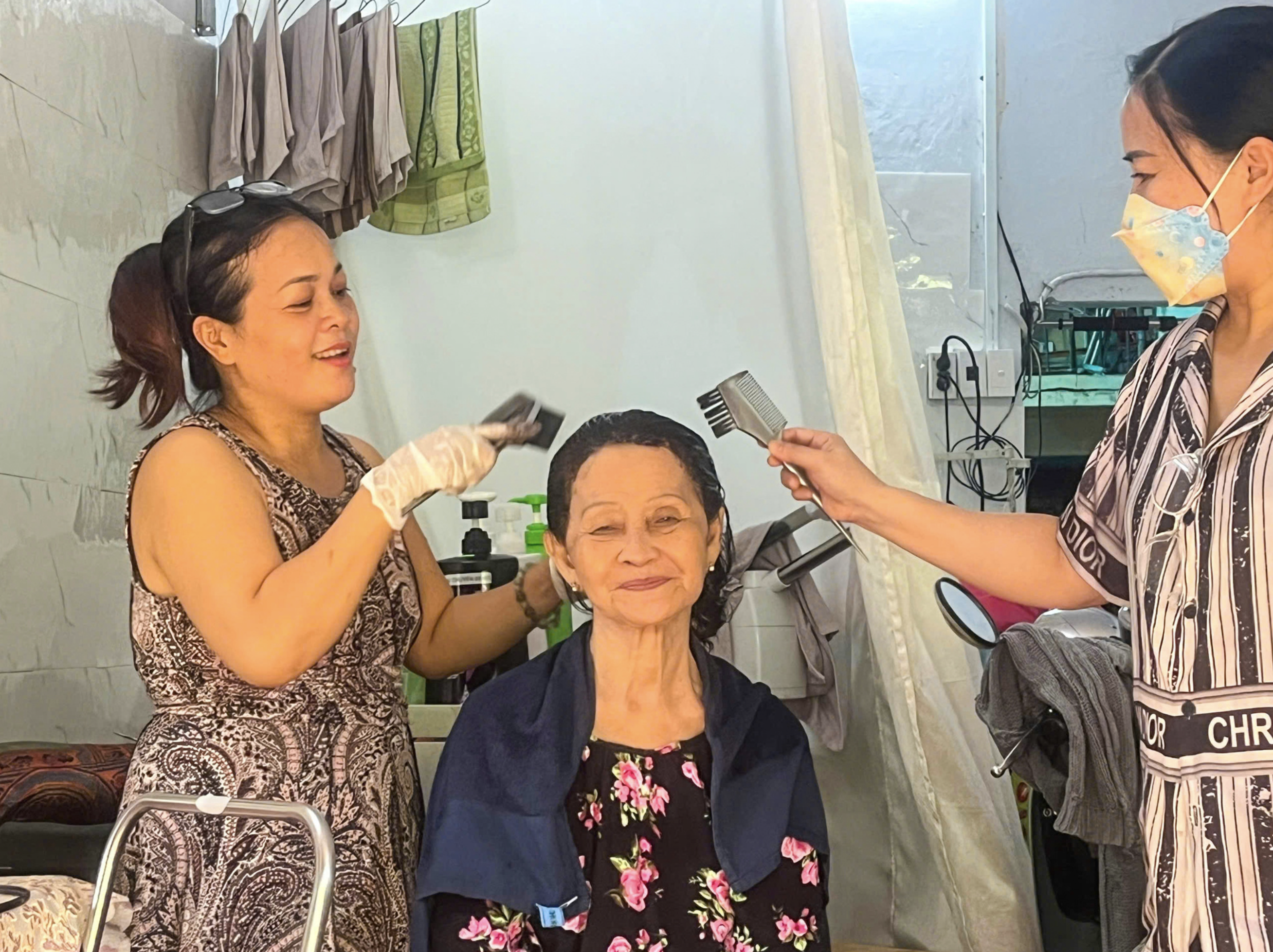 Suong is happy to have her hair cut and styled at a hair salon in the trackside village in Phu Nhuan District for the first time. Photo: Le Phuc Hung