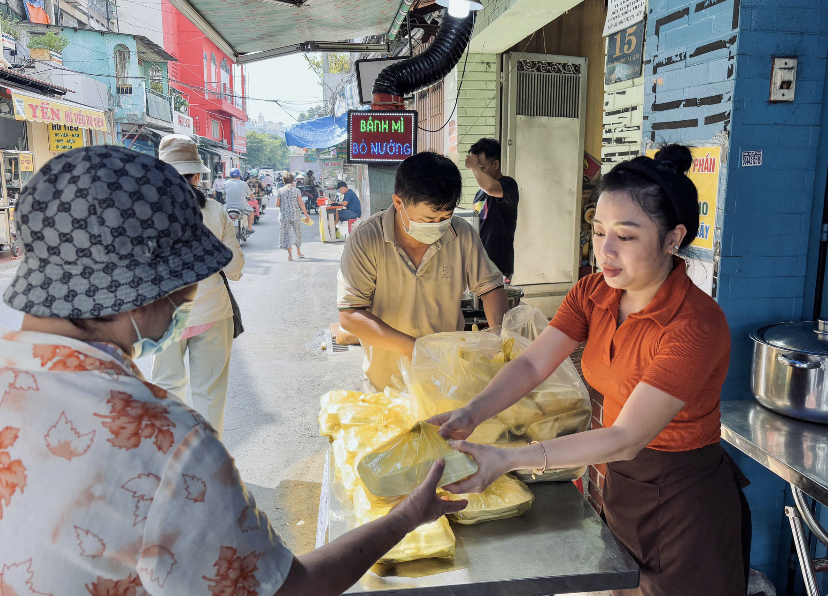 Tai and Van Anh donates boxes of rice to disadvantaged people on a street near the trackside village in Phu Nhuan District, Ho Chi Minh City. Photo: Vo Tran Ngoc Tram