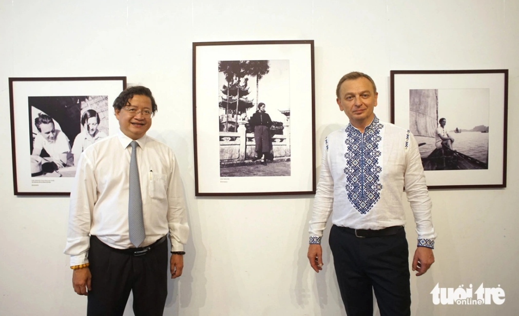 Nguyen Minh Nhut (L), deputy director of the Ho Chi Minh City Department of Culture and Sports and Ukrainian Ambassador to Vietnam Gaman Oleksandr pose for a photo with the photos of Ukrainian artist Sofia Yablonska. Photo: H. Vy / Tuoi Tre